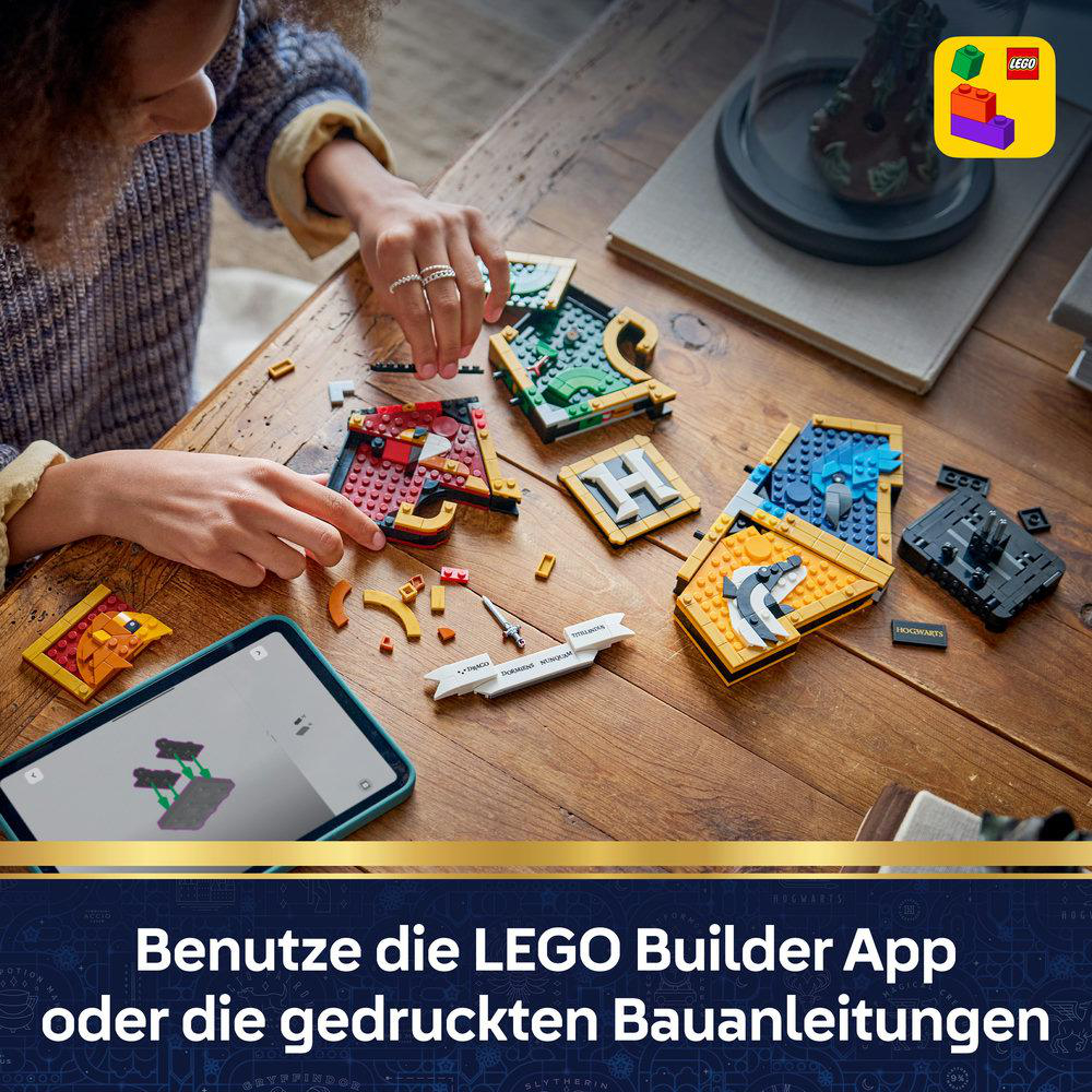 Person baut LEGO Harry Potter-Sets auf Holztisch, Handy zeigt Anleitung.