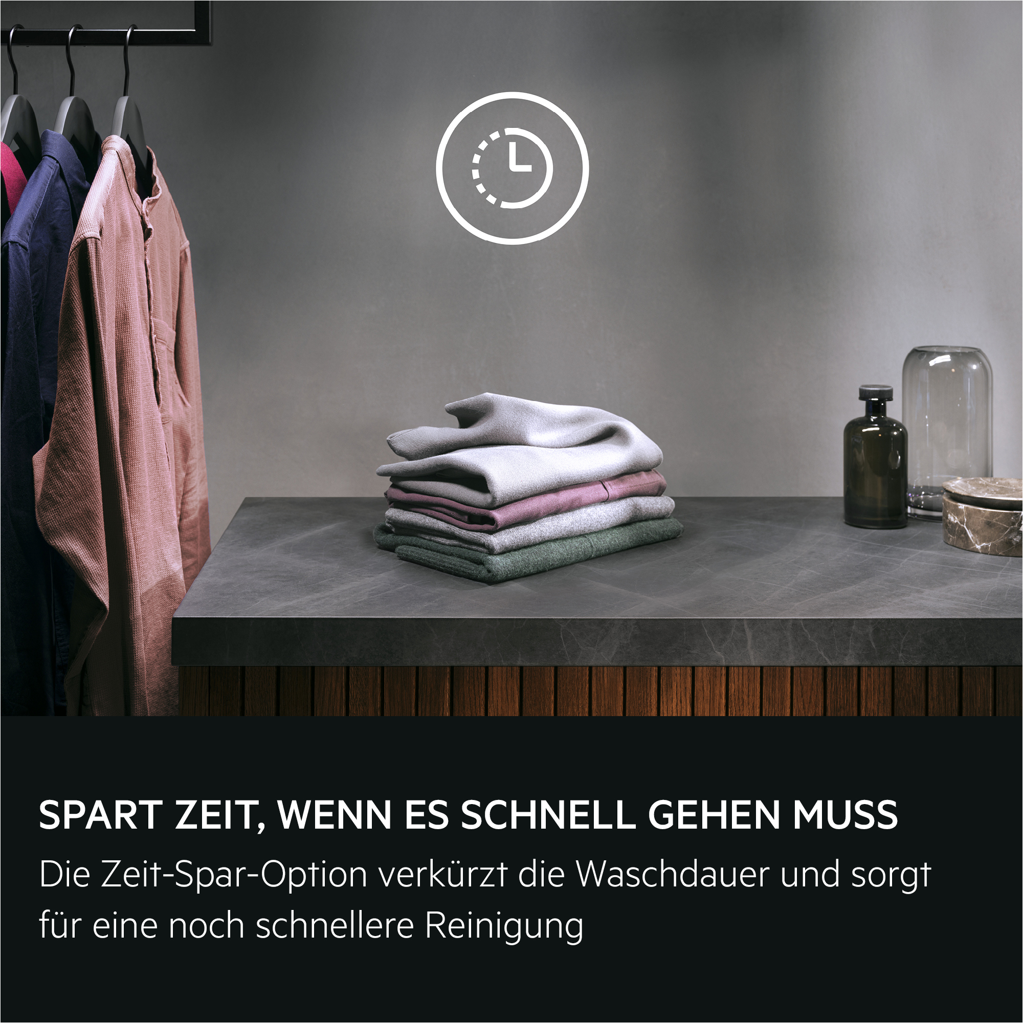 Ein Kleiderständer mit Kleidung und ein Stapel gefalteter Kleidung.