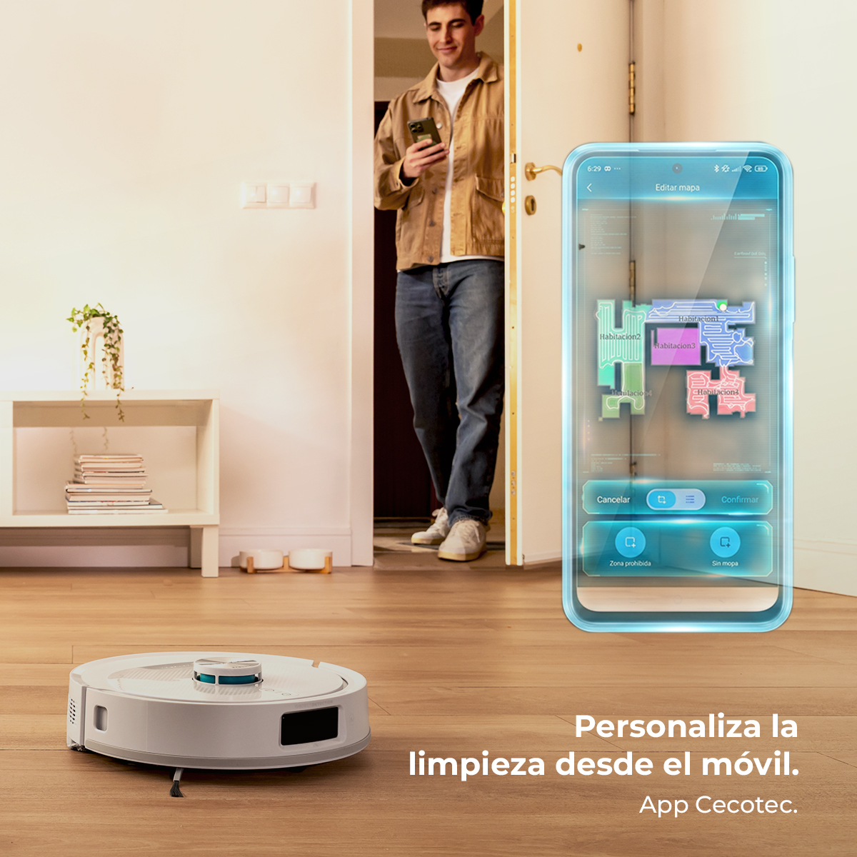 Hombre con móvil mira una app de mapa de habitación. Un robot aspirador en el suelo.