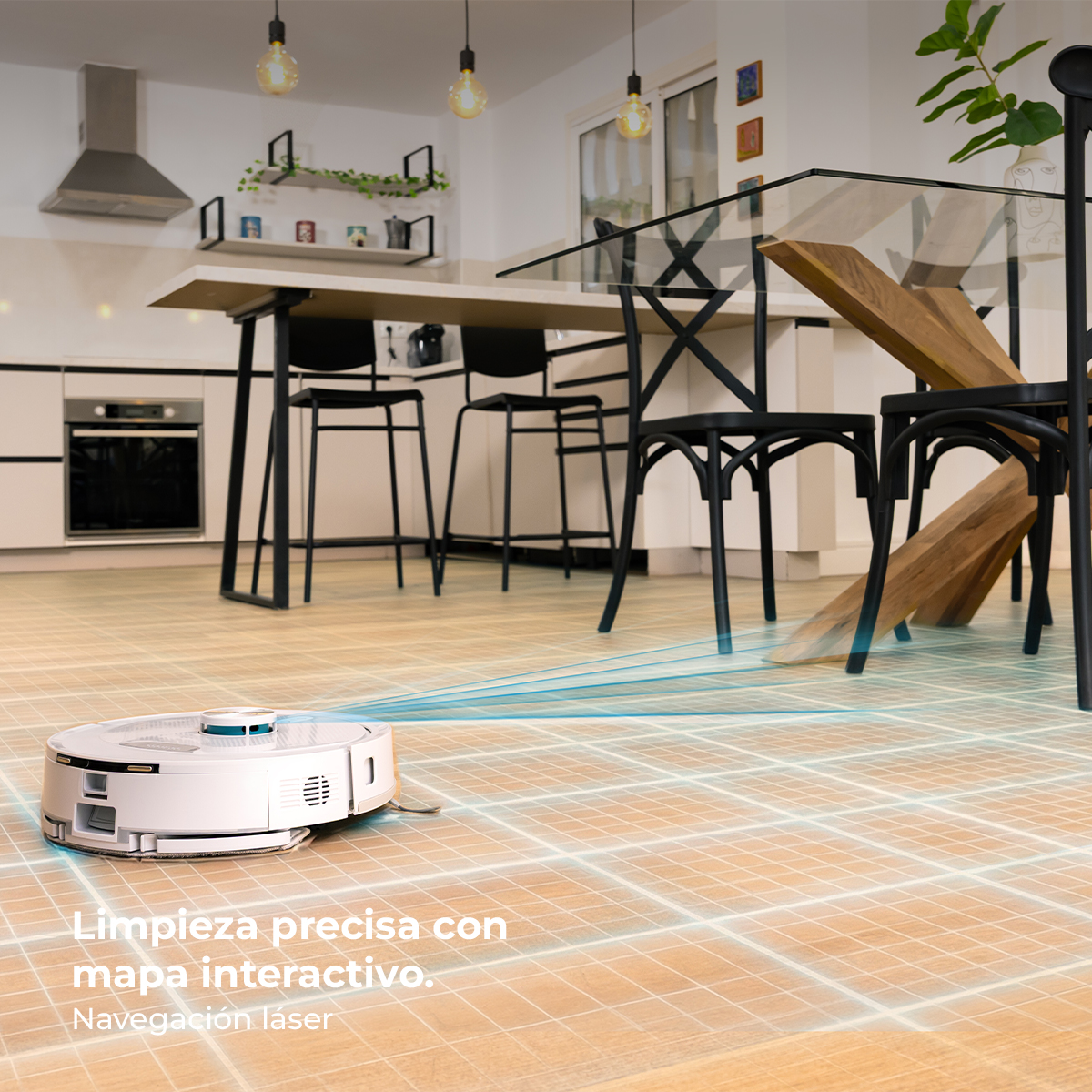 Un robot aspirador blanco limpia un suelo de madera en una cocina moderna con mesa.