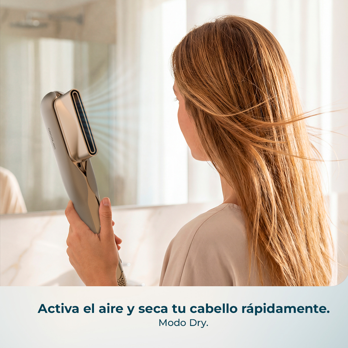 Una mujer se seca su pelo largo y castaño claro con un secador moderno en un baño.