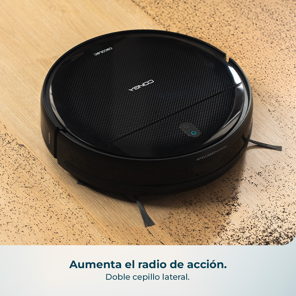 Un robot aspirador negro limpia suciedad de un suelo de madera.