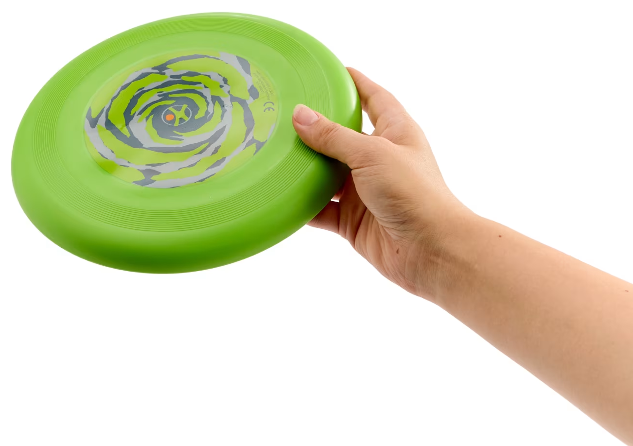 Egy kéz egy zöld, spirálmintás frizbit tart.