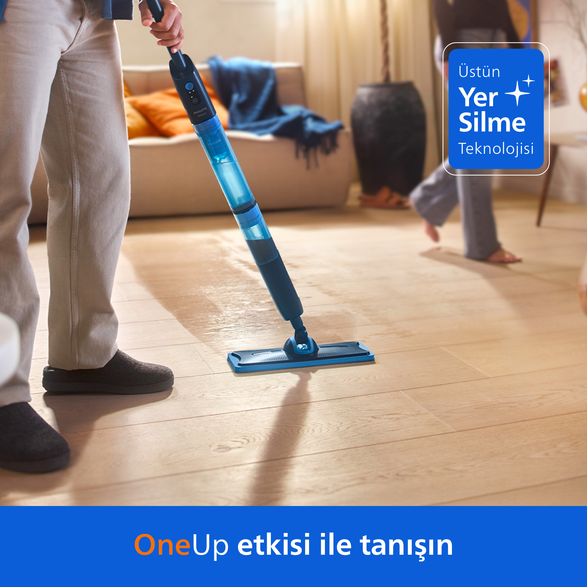 Kişi mavi sprey paspasla zemini siliyor. Oturma odası sahnesi.