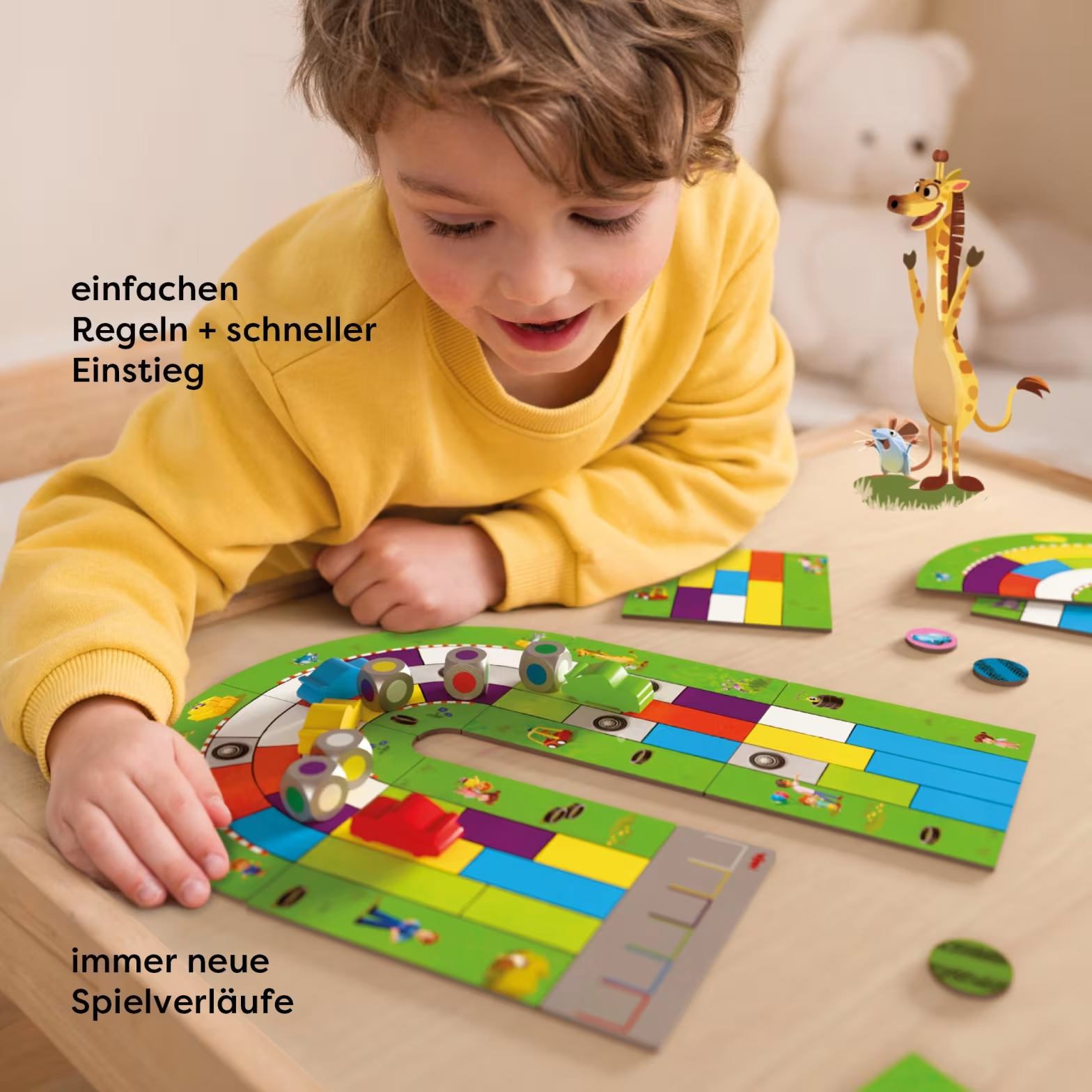 Egy fiú színes társasjátékot játszik autókkal, kockákkal és egy zsiráffigurával.