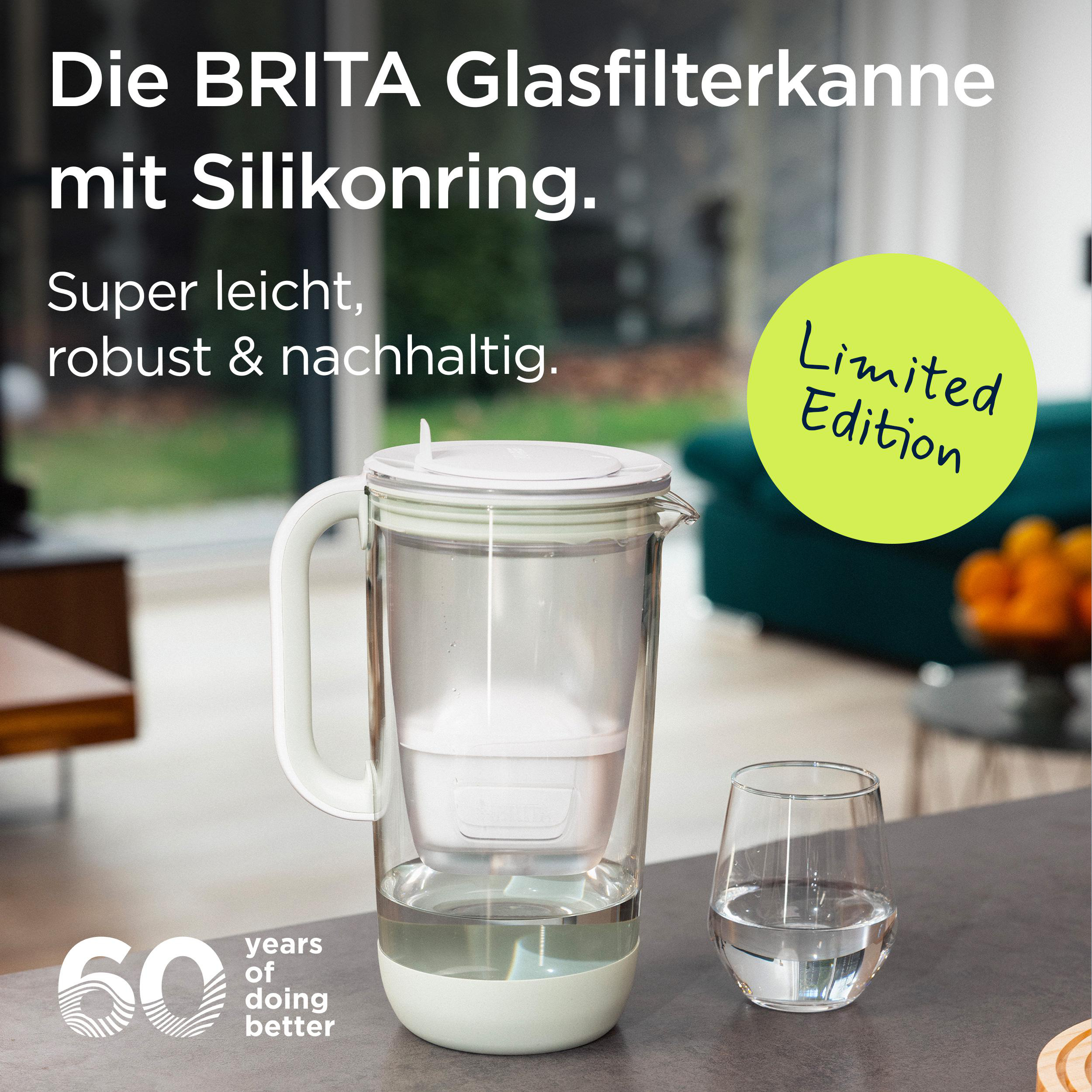 Eine BRITA Glasfilterkanne mit Silikonring und ein Glas Wasser auf einem Tisch.