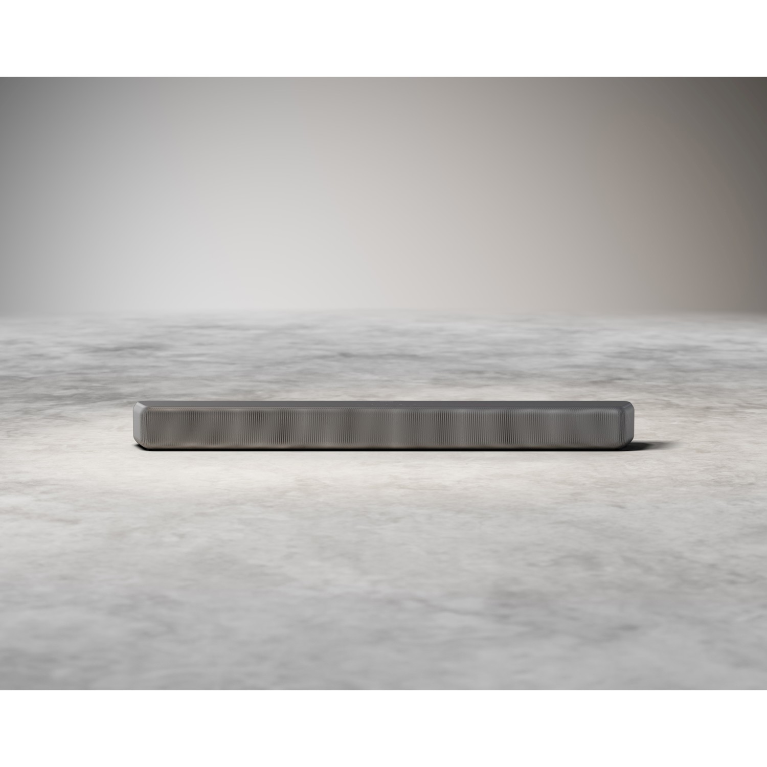 Soundbar grigia su pavimento in cemento.