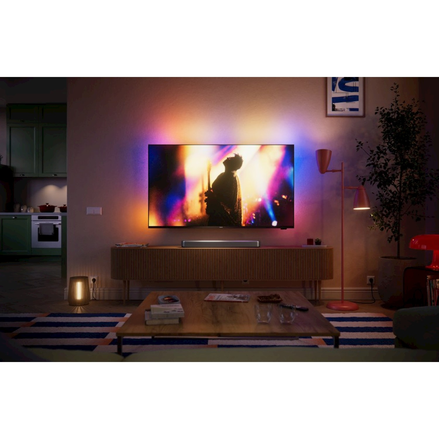 Un soggiorno moderno con TV che mostra un concerto, luci colorate e mobili.