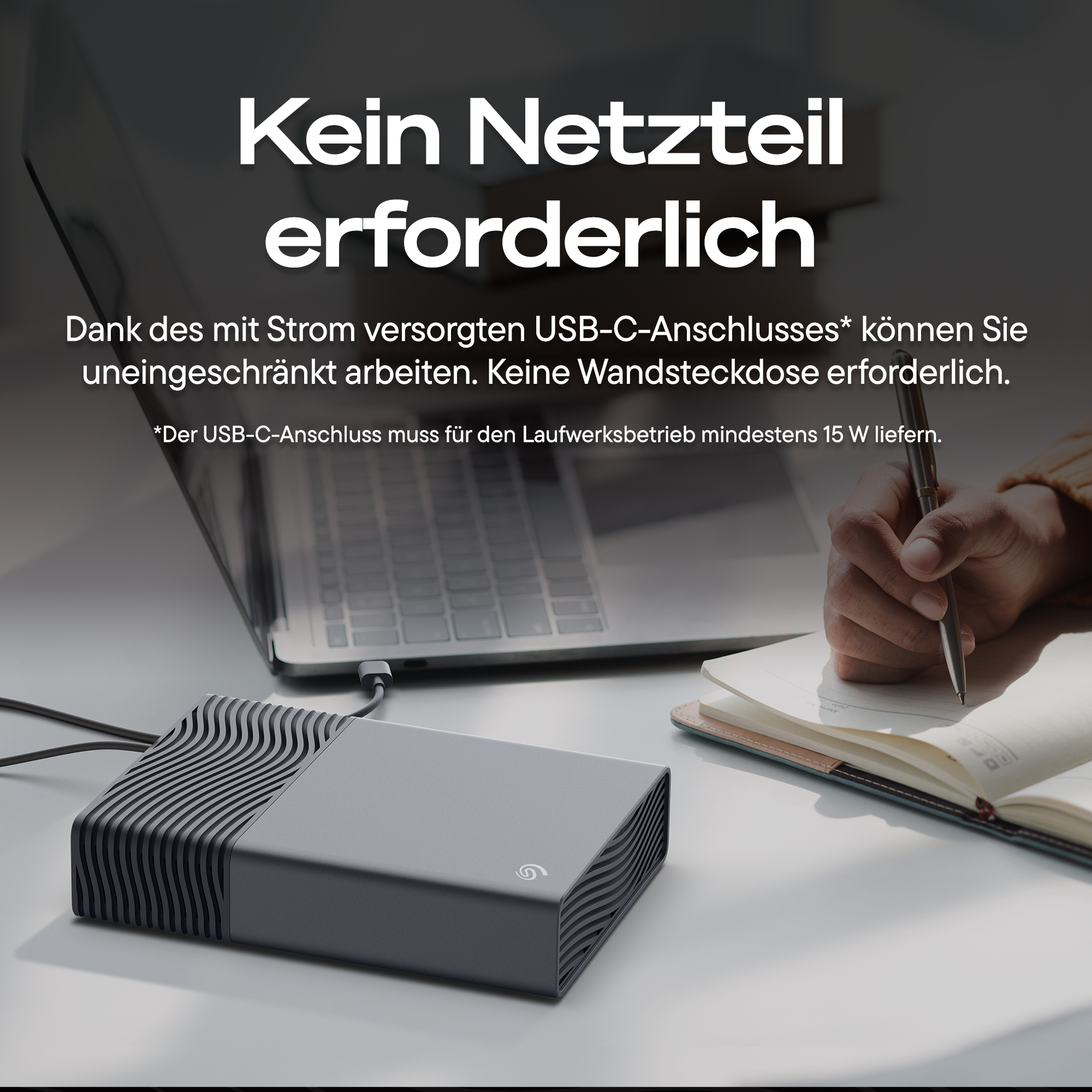 Externes Laufwerk mit USB-C-Anschluss neben Laptop und Notizbuch.