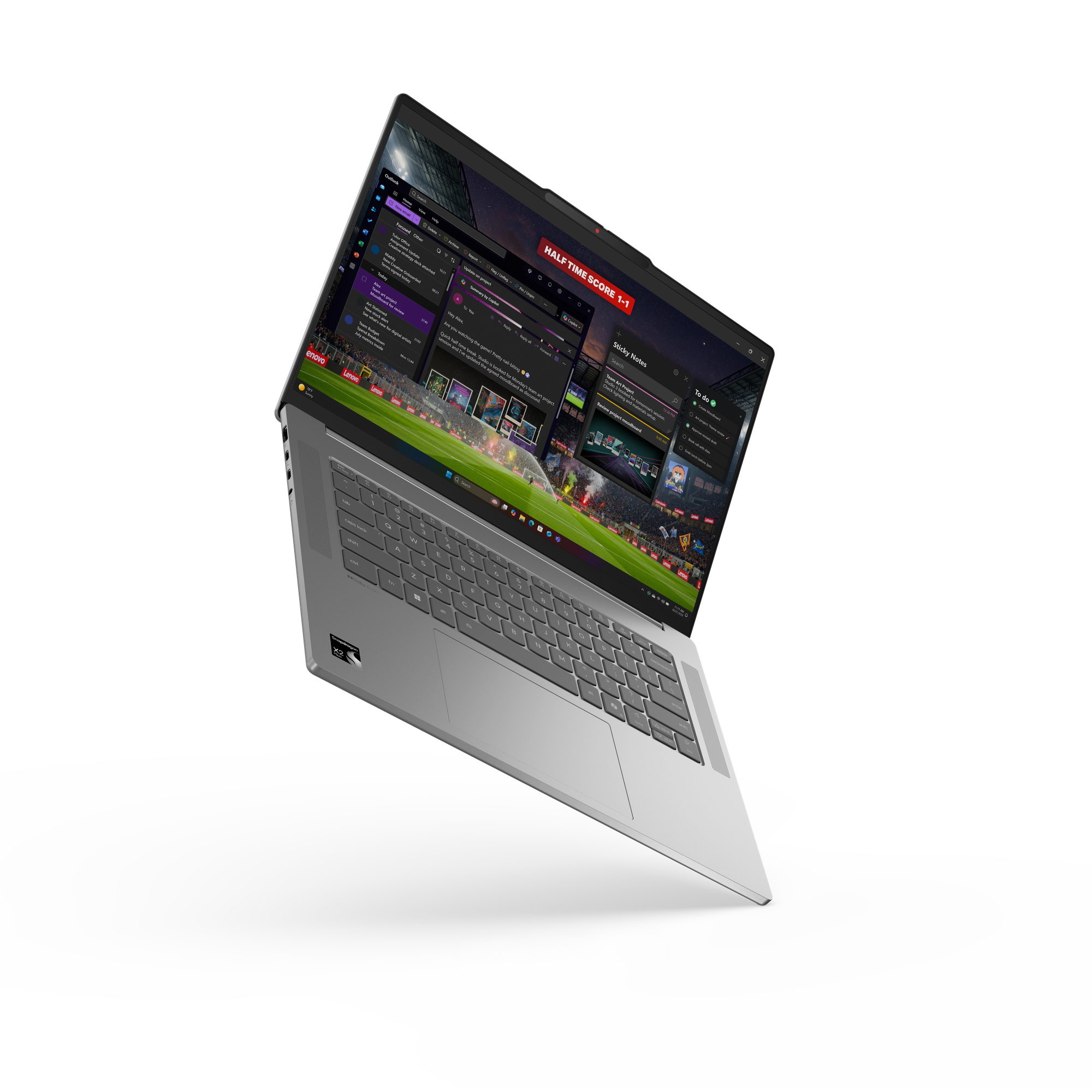 Un laptop argento mostra una partita di calcio e un'app di posta, punteggio 1-1.