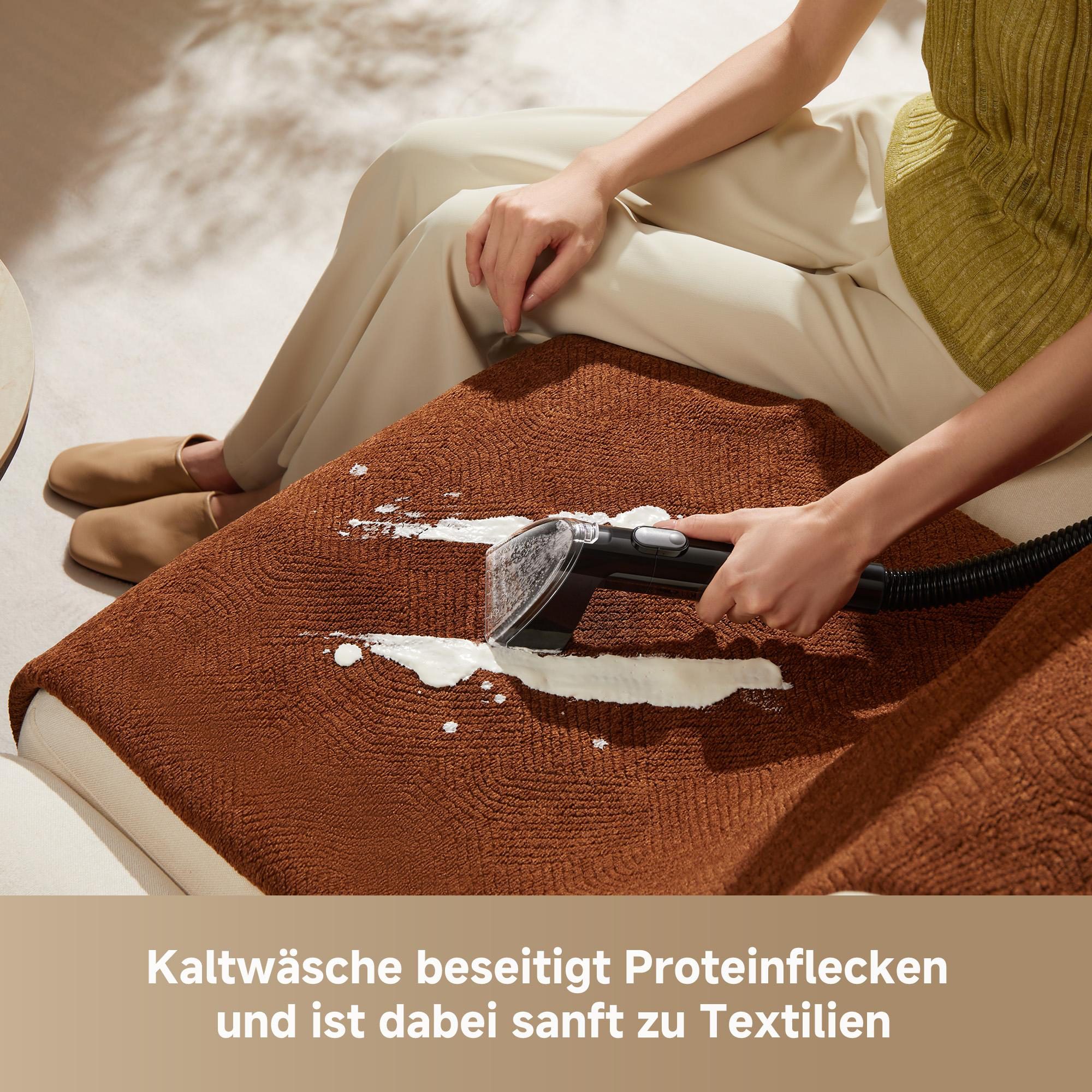 Eine Person reinigt einen braunen Polsterfleck mit einem Reinigungsgerät.