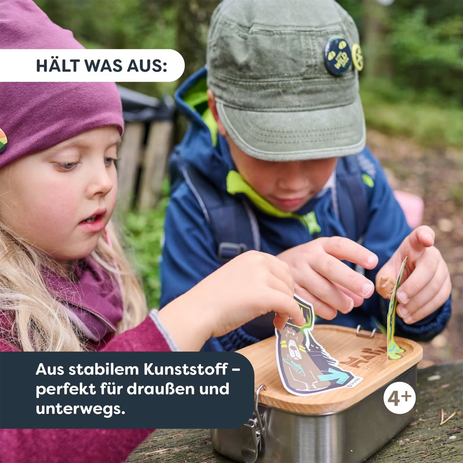 Két gyerek odakint egy uzsonnás dobozzal, matricákat ragasztanak.