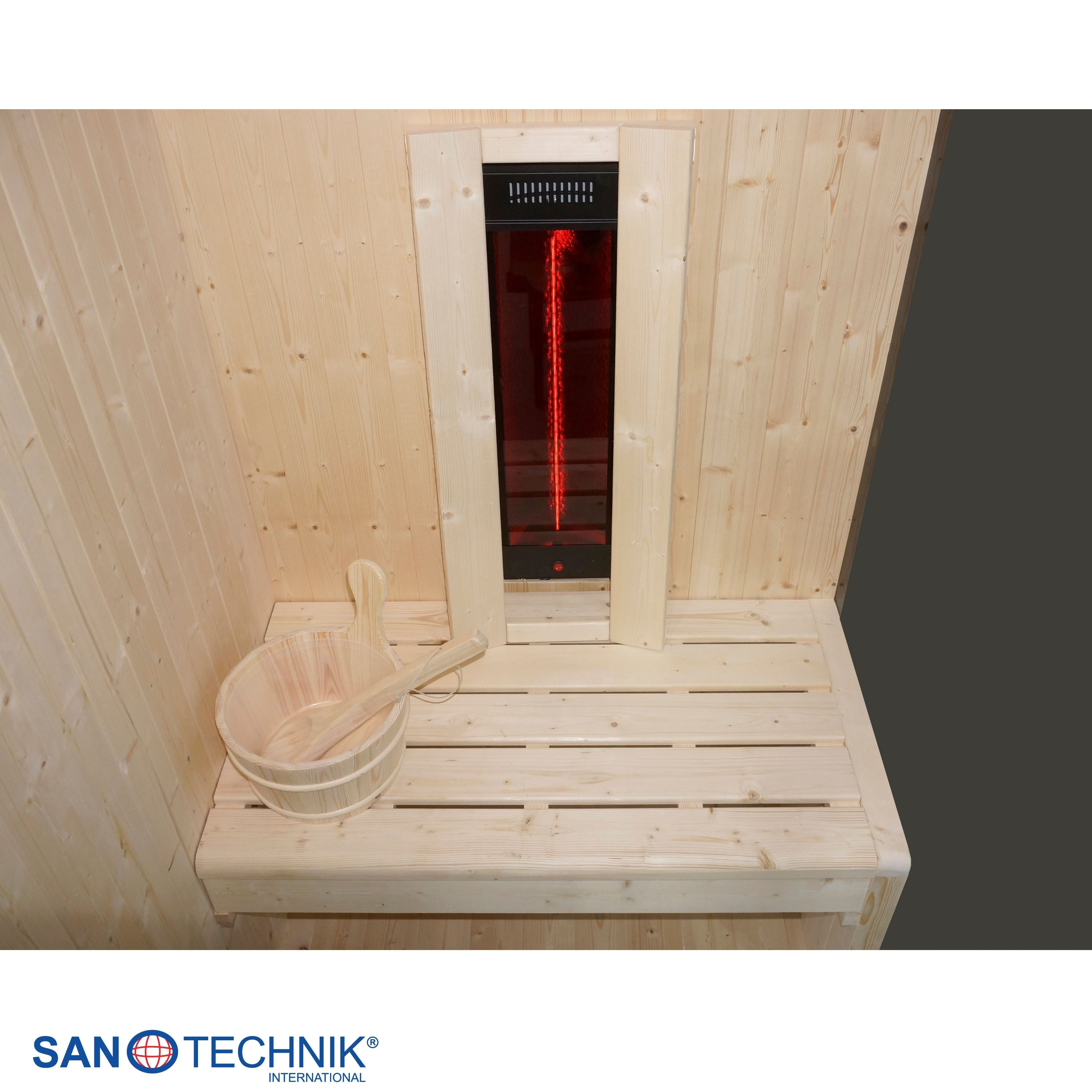 Holzsauna mit roter Infrarotlampe und Holzeimer mit Schöpfkelle.