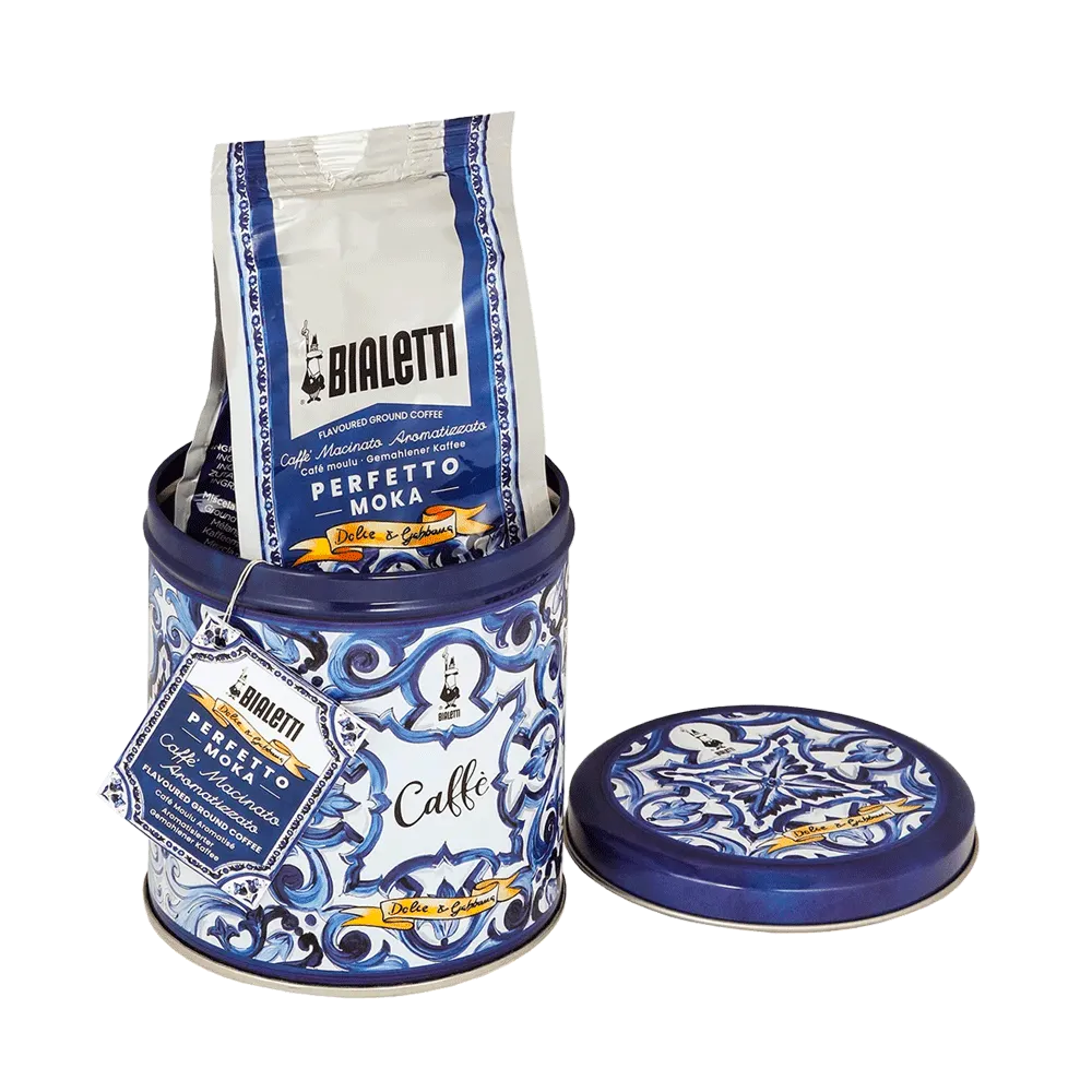 Una lata azul con estampado floral contiene café y tiene una tapa separada.