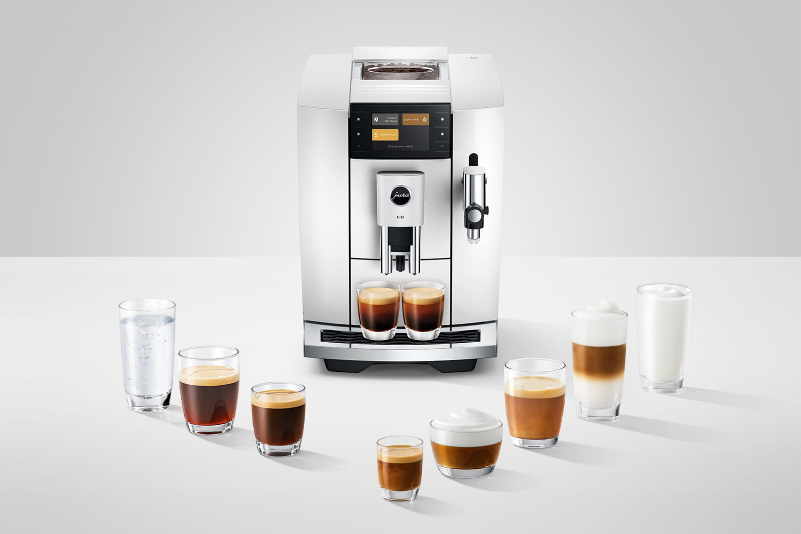 Una macchina da caffè bianca con diverse specialità di caffè in bicchieri.