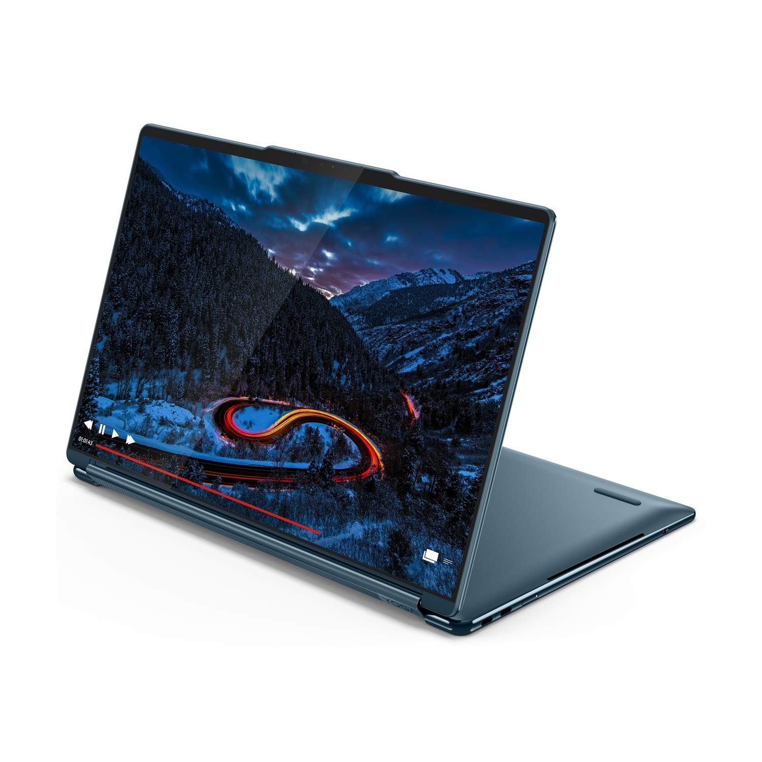 Un laptop blu mostra un video di una strada tortuosa in un paesaggio montano innevato di notte.