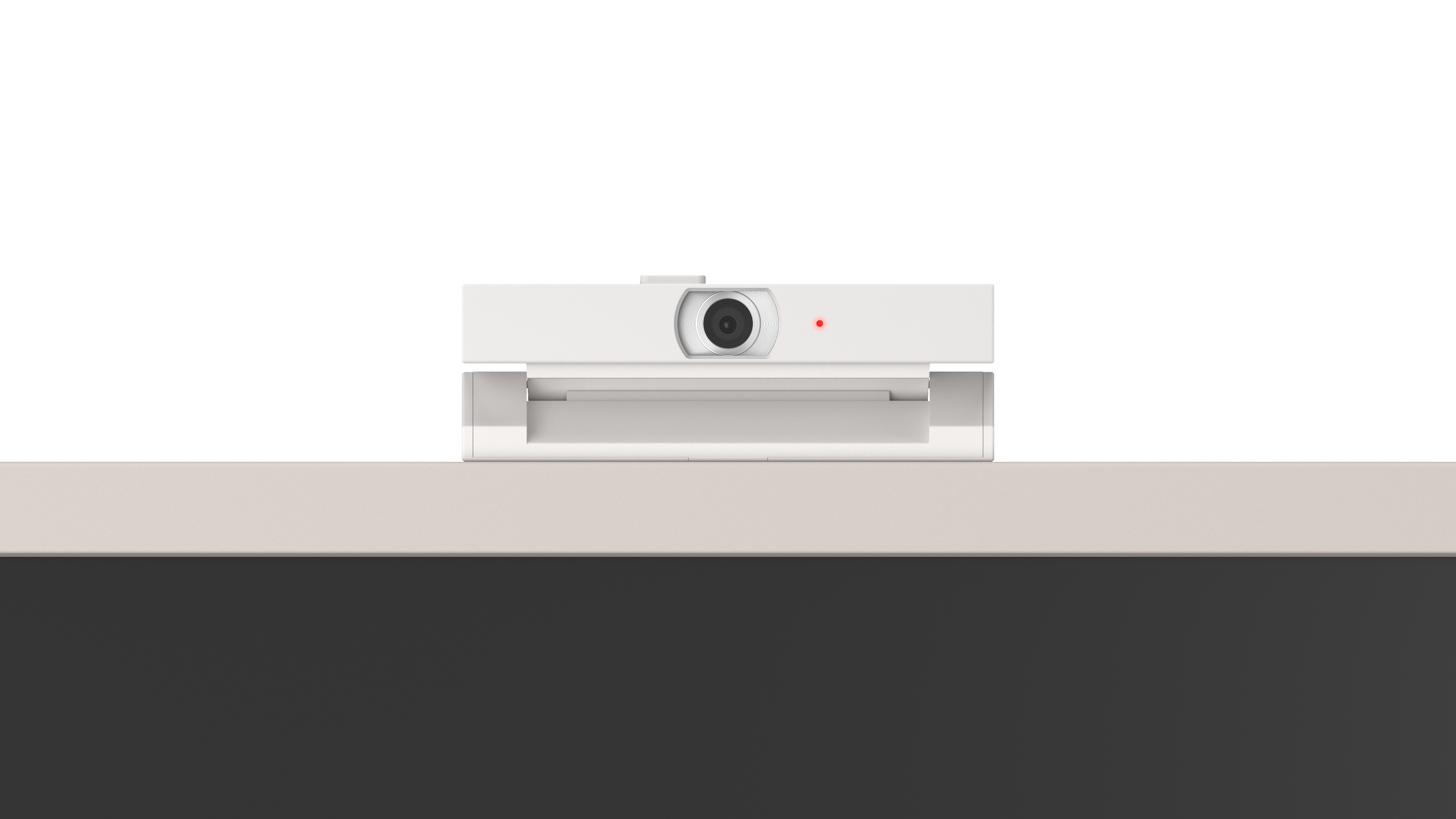 Eine weiße Webcam mit rotem Lämpchen sitzt auf einem hellbeigen Rand.