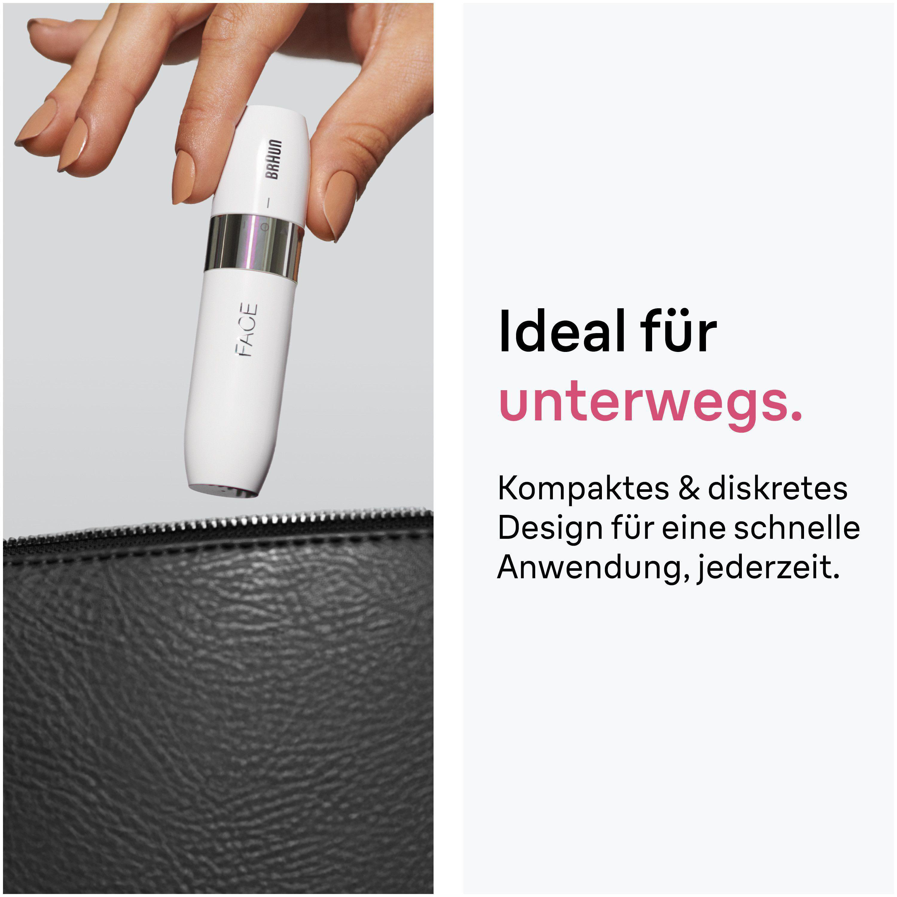 Eine Hand hält ein weißes Braun Gesichtsreinigungsgerät über einer schwarzen Tasche.