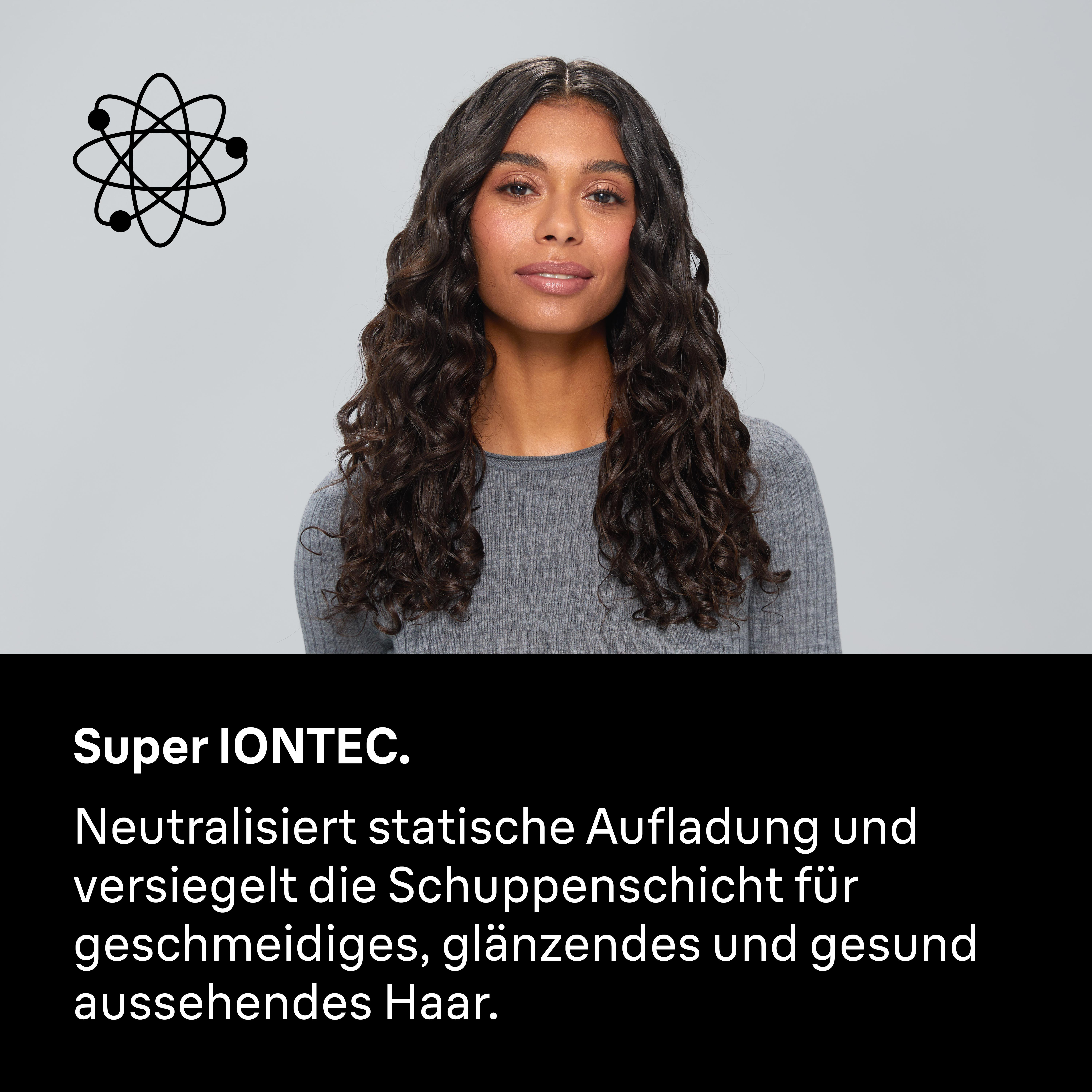 Frau mit dunklem, lockigem Haar vor grauem Hintergrund mit Atomsymbol.