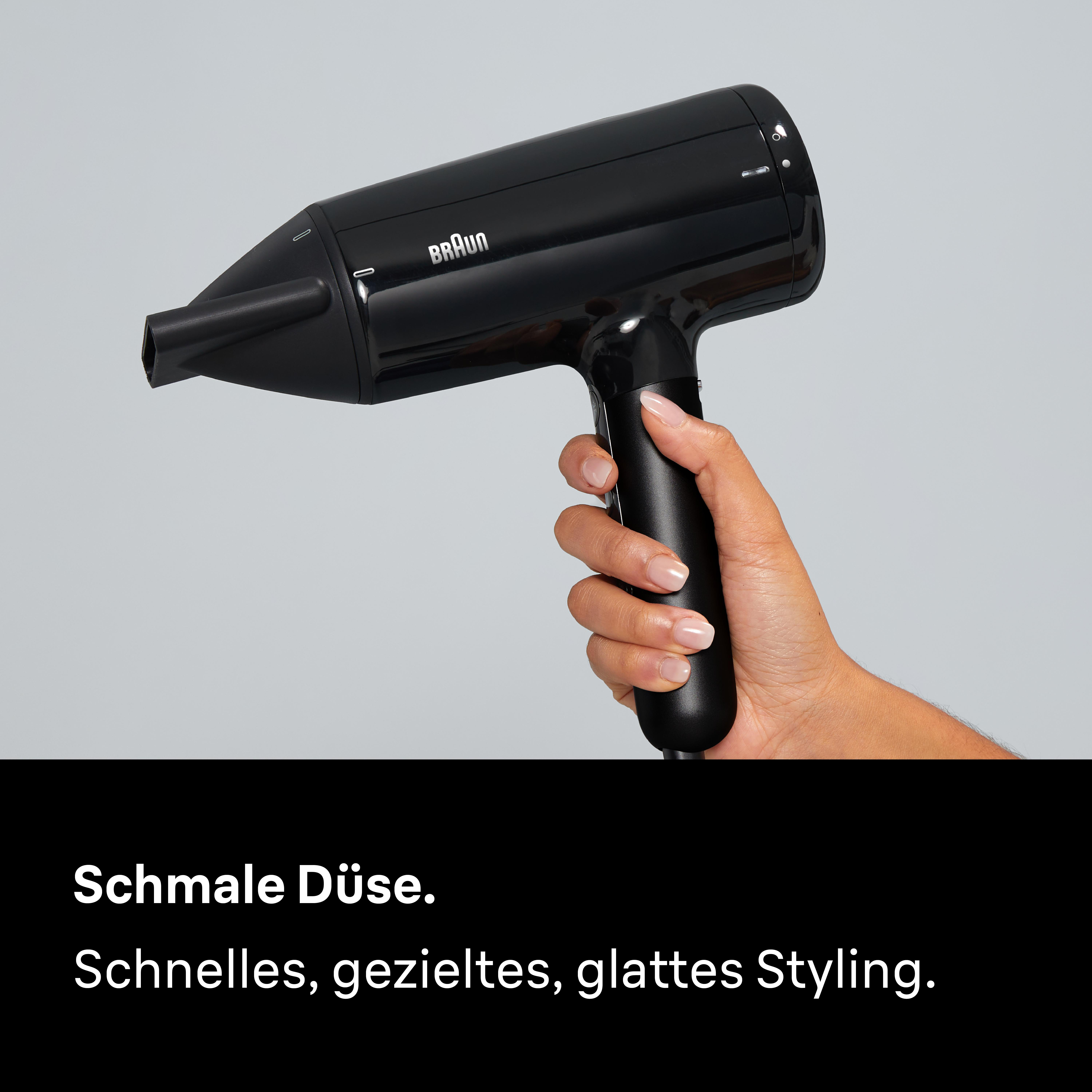 Eine Hand hält einen schwarzen Braun Haartrockner mit schmaler Düse.