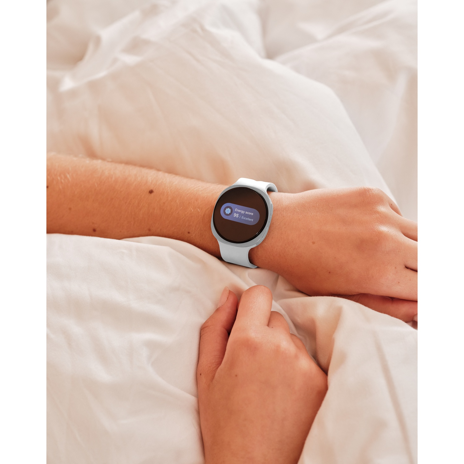 A person lies in bed, wearing a smartwatch showing an energy score of 95.