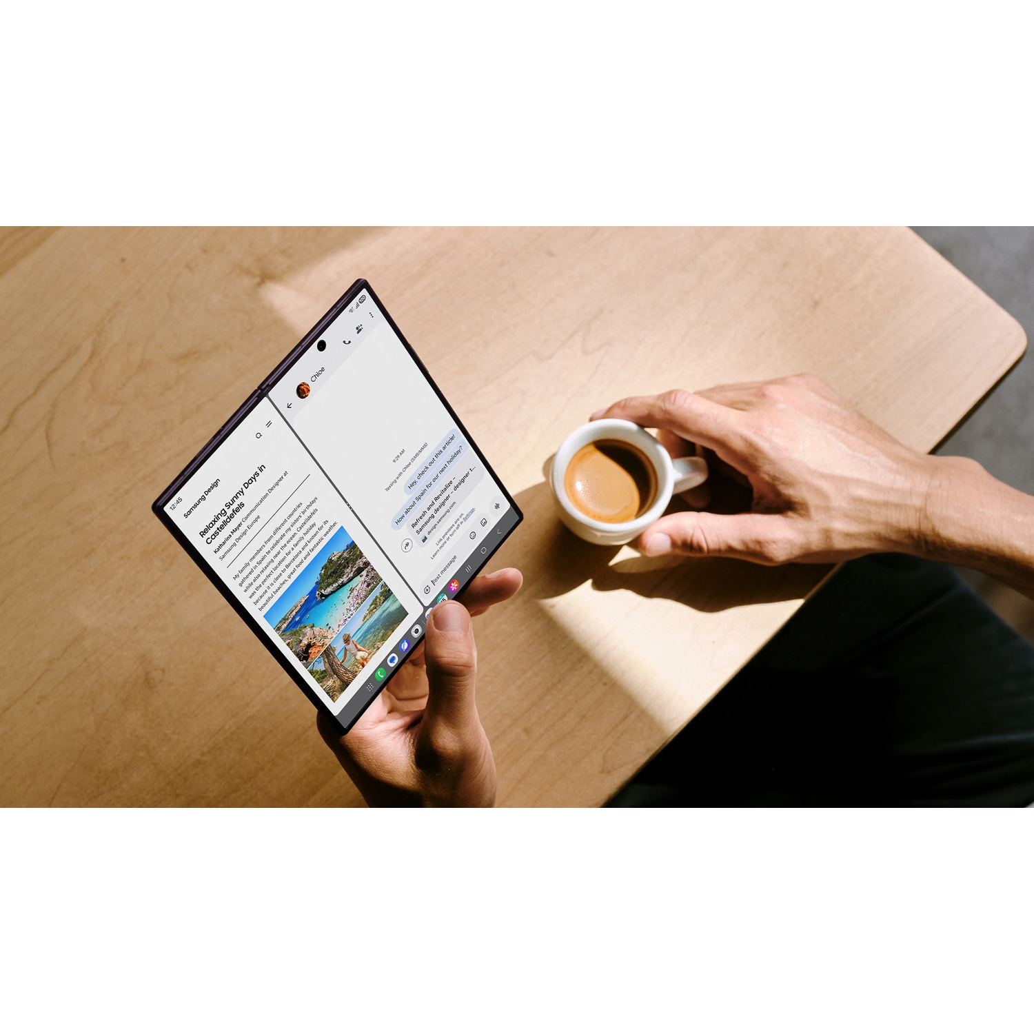 Hands hold a foldable phone showing a travel article. A cup of espresso sits nearby.
