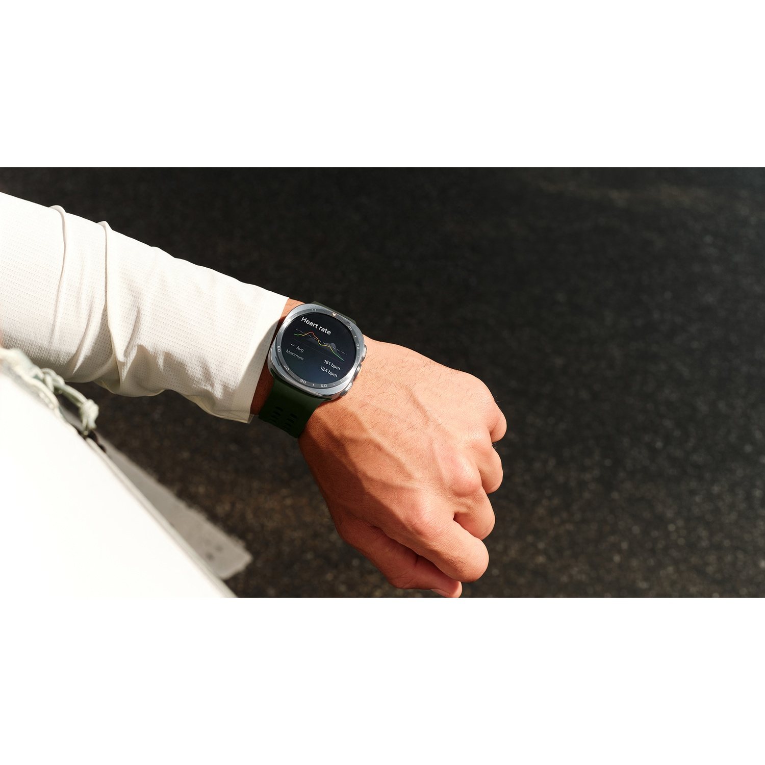 A man wears a green smartwatch displaying heart rate data.