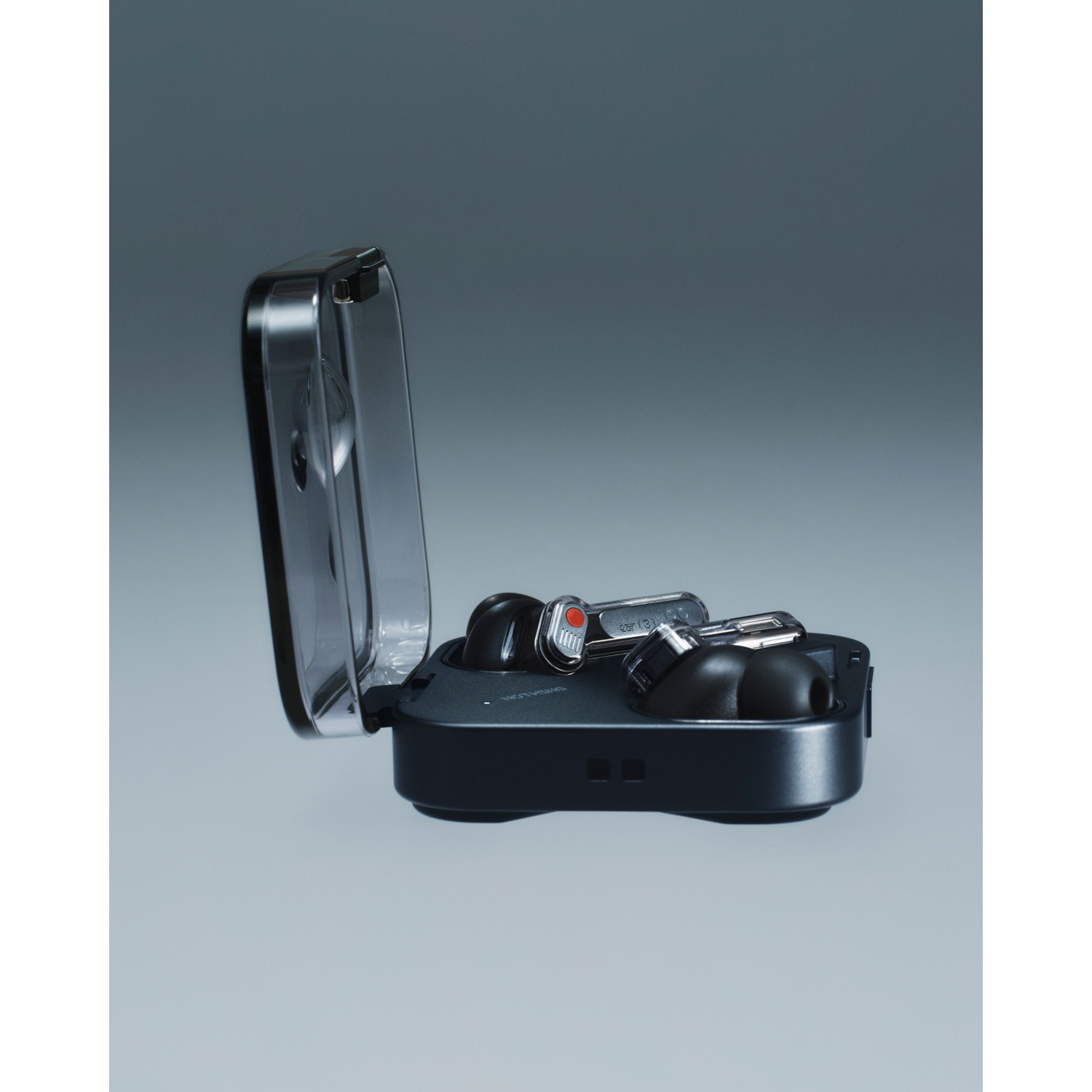 Auricolari wireless neri in custodia di ricarica trasparente, su sfondo grigio.