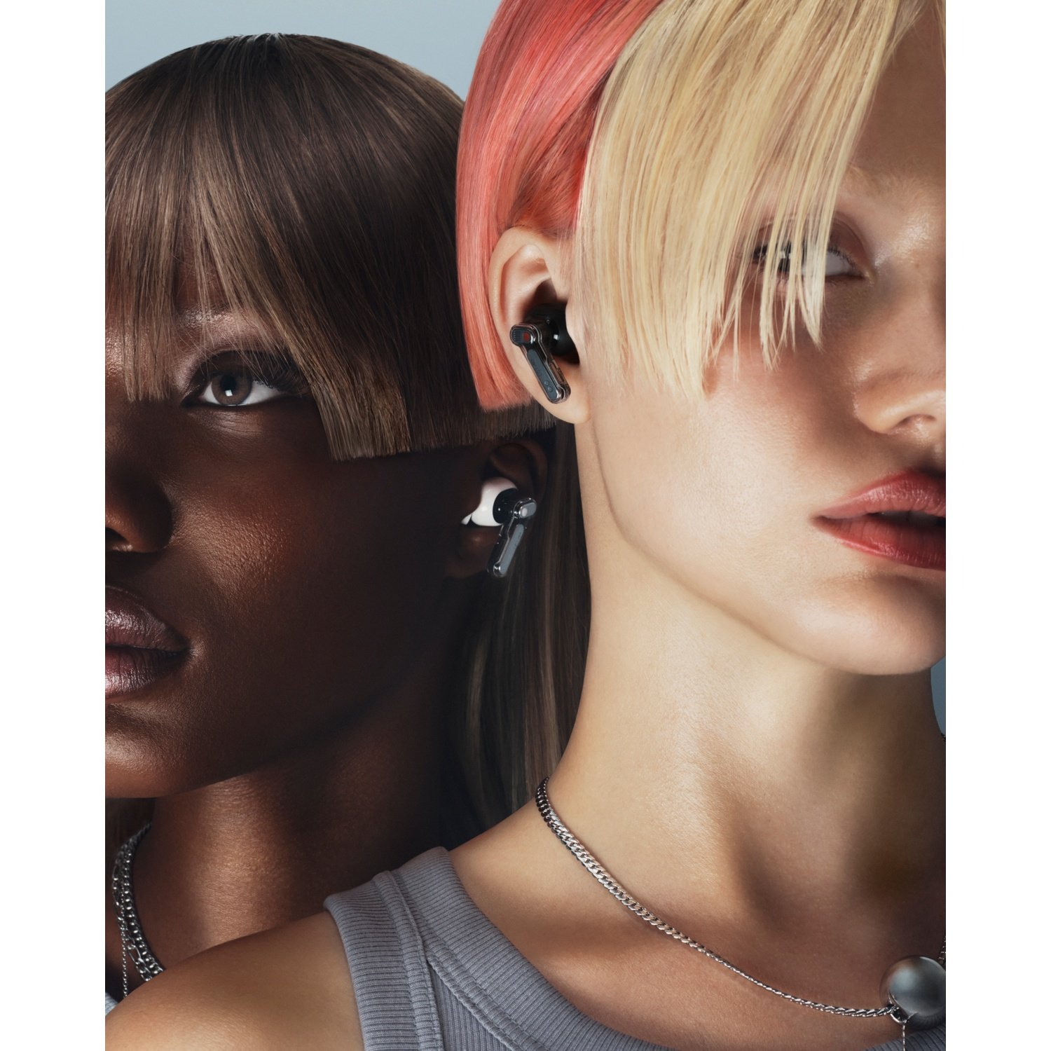 Due donne con acconciature alla moda e auricolari su sfondo blu.