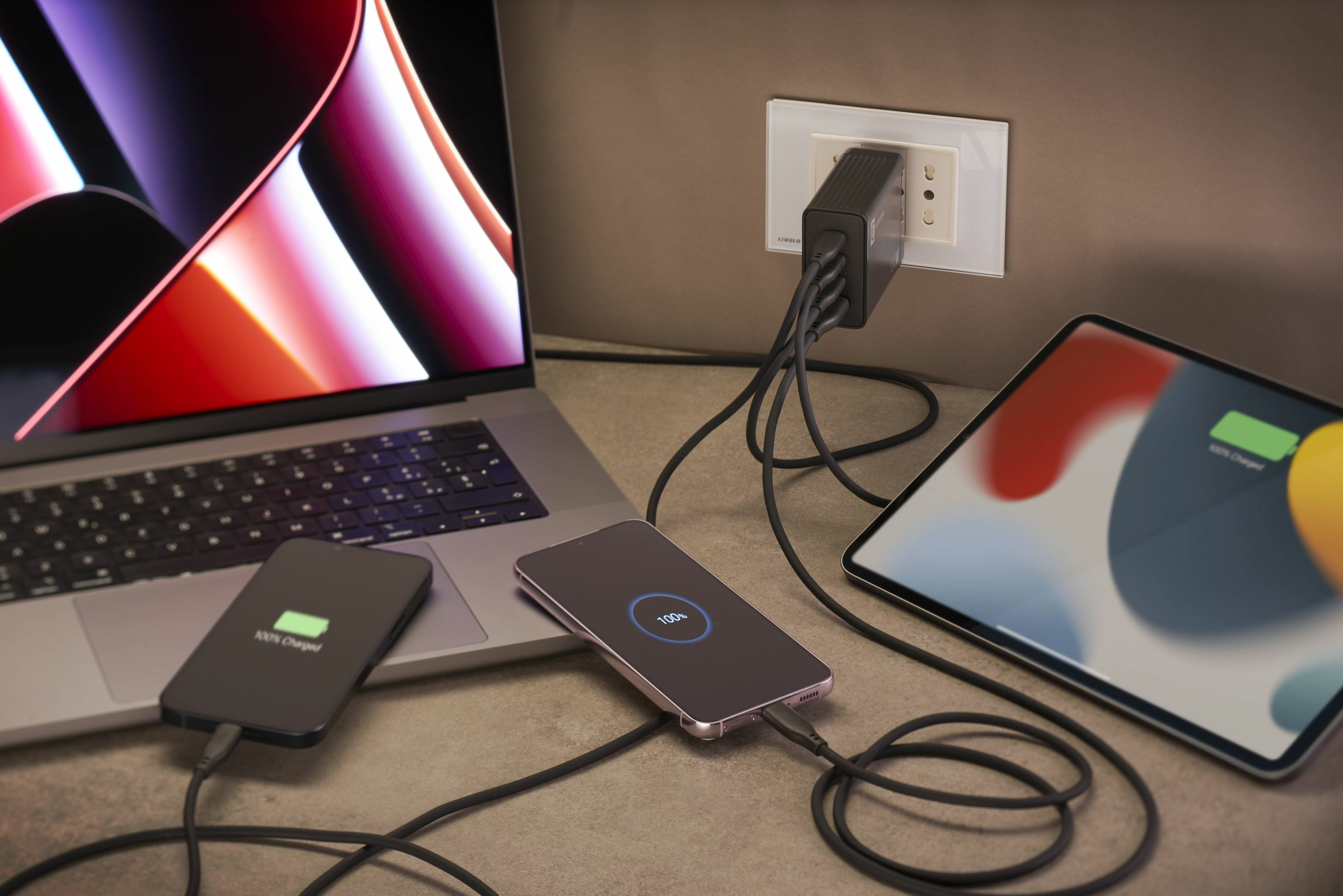 Un portátil, dos teléfonos inteligentes y una tableta se cargan simultáneamente.