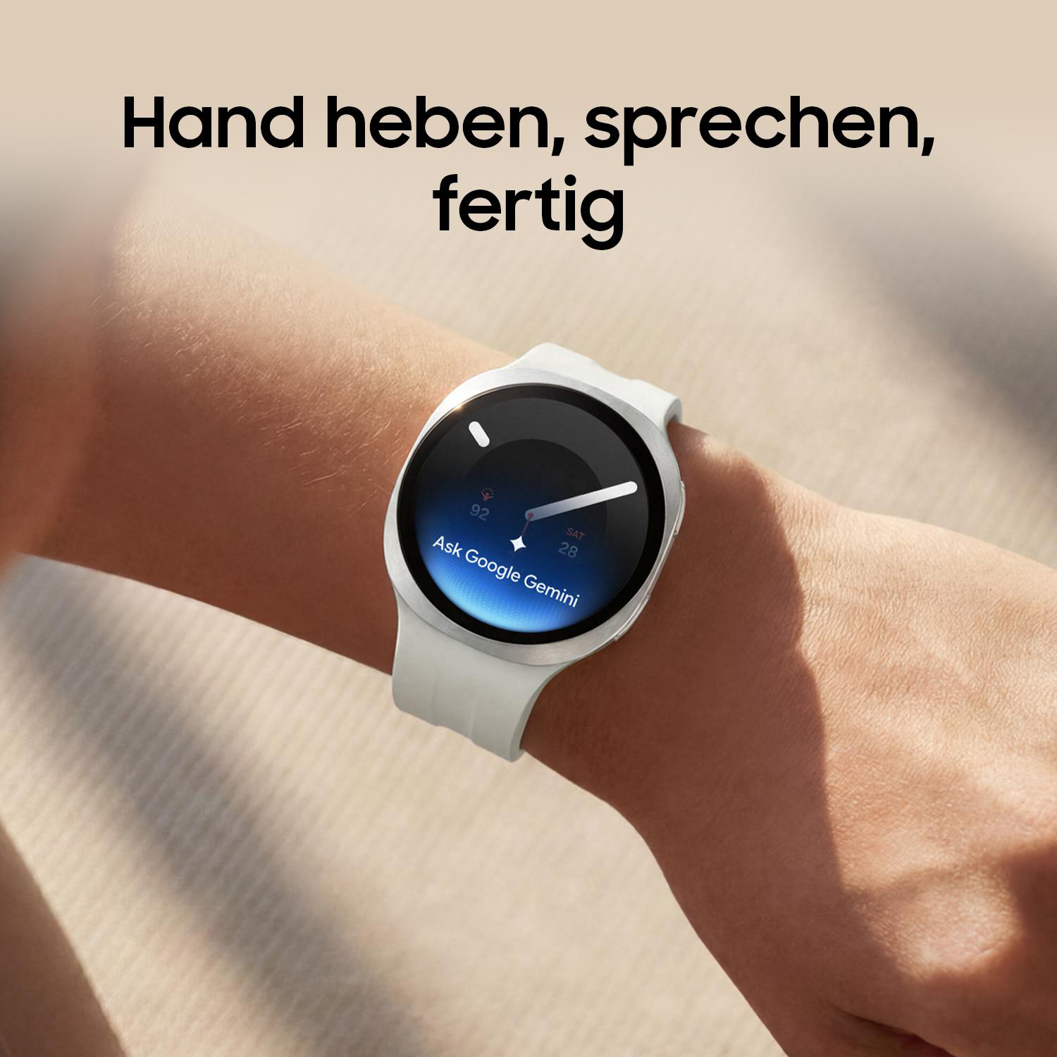 Eine weiße Smartwatch am Handgelenk zeigt „Ask Google Gemini“ an.