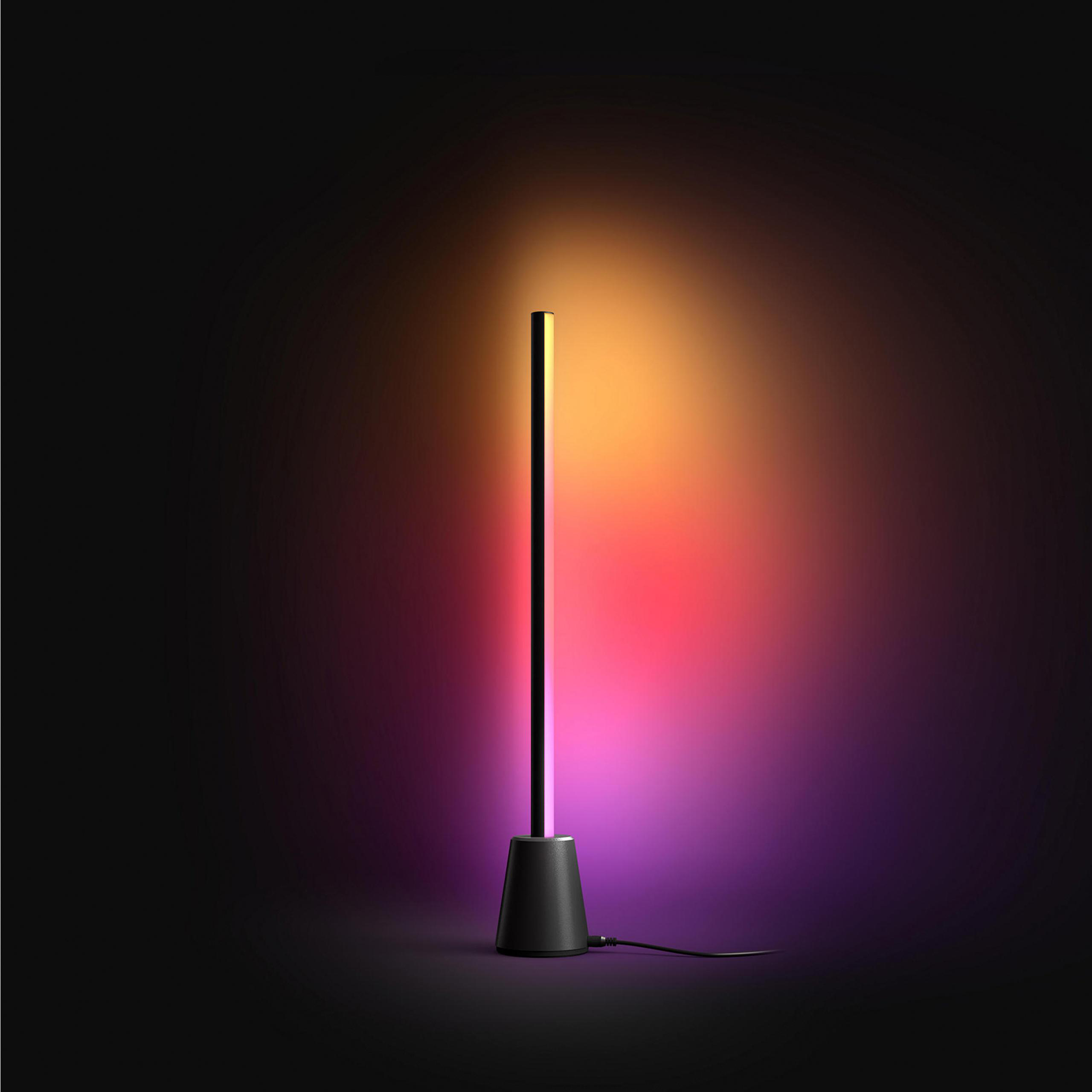 Ein schlanker schwarzer Lichtstab leuchtet in Pink, Orange und Gelb vor einem dunklen Hintergrund.