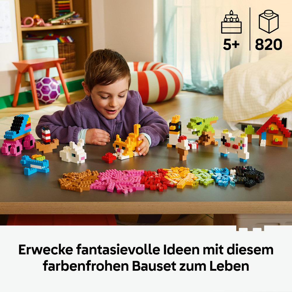 Kind spielt mit bunten Bausteinen, die Tiere und Häuser bilden.