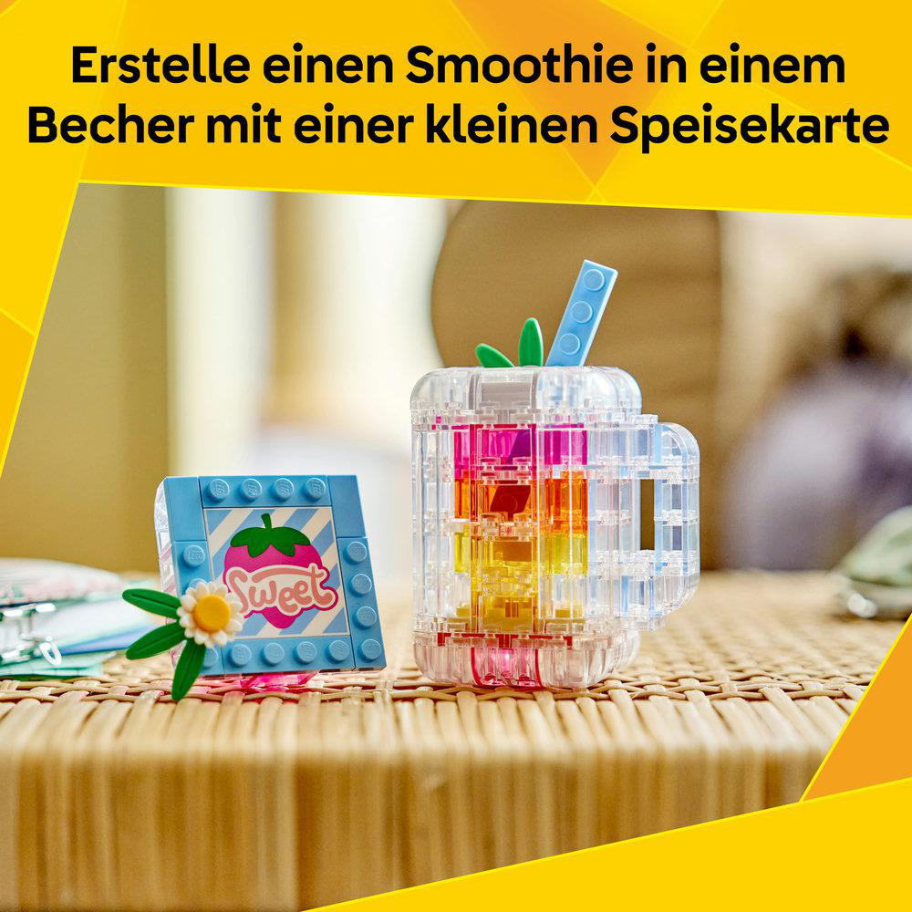 Bunter Lego-Smoothie-Becher mit Erdbeer-Dekor und Blume.
