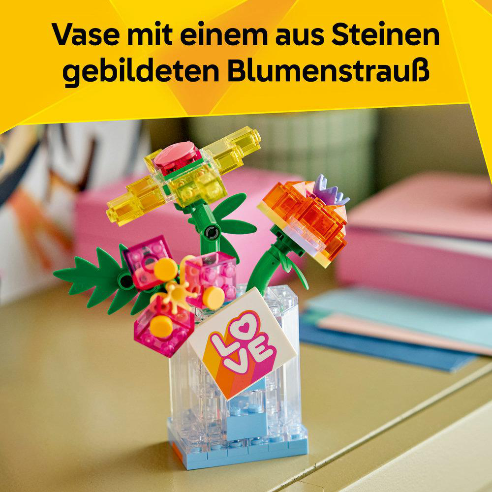 Bunte Lego-Blumen in einer durchsichtigen Vase mit "Love"-Aufdruck.