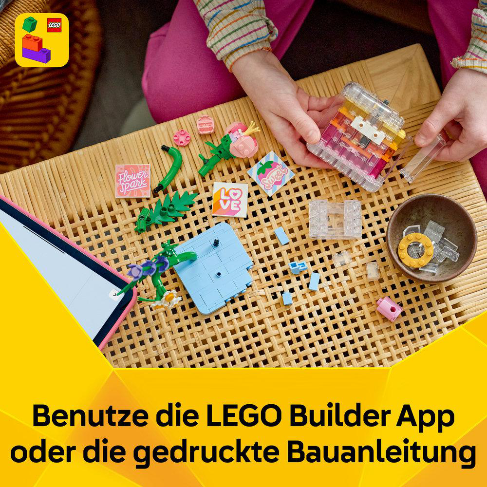 LEGO Steine und Zubehör auf gewebter Oberfläche, Tablet mit LEGO Logo.