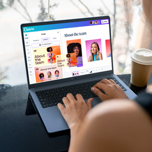 Eine Person tippt auf einem Laptop, auf dem Canva mit einer "Über das Team"-Folie angezeigt wird.