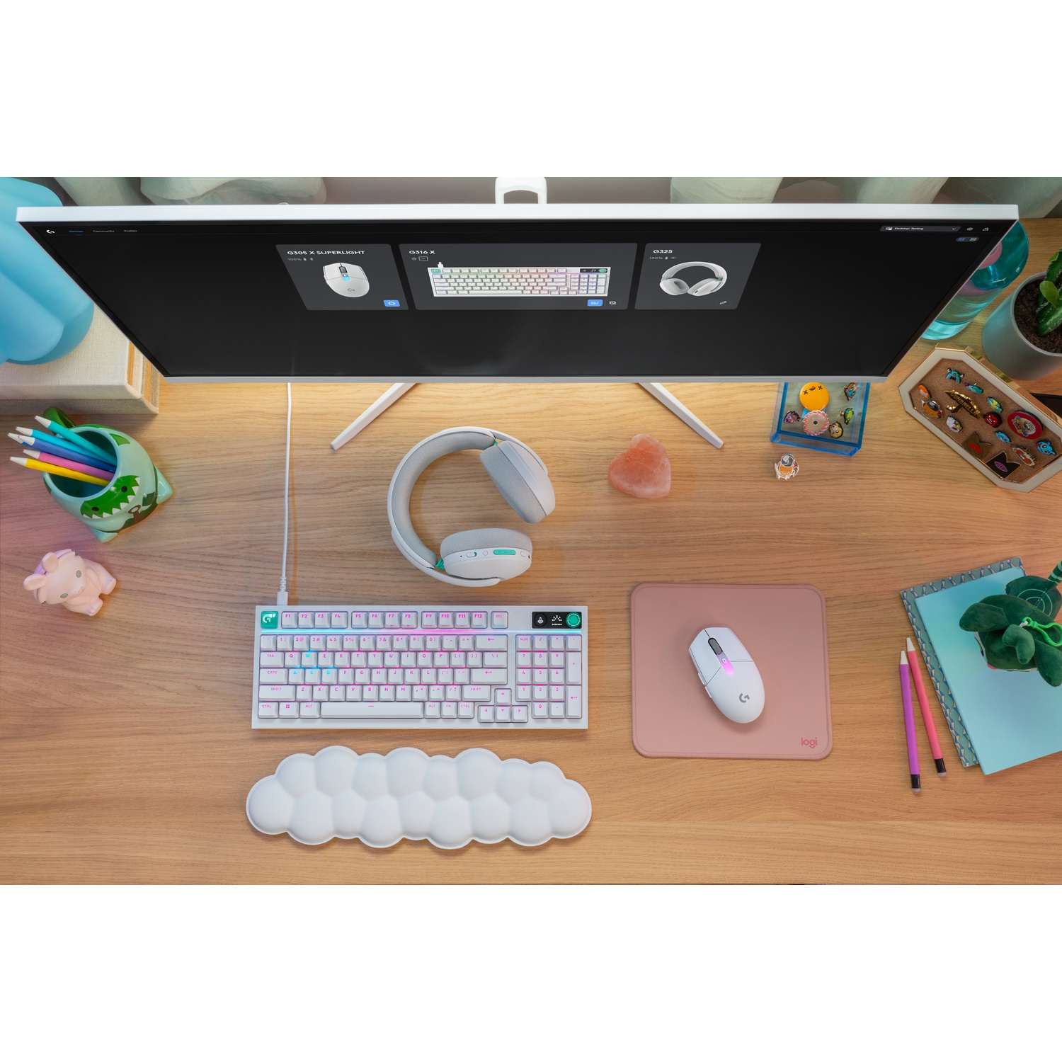 Un setup gaming bianco con tastiera, mouse, cuffie e tappetino su scrivania in legno.