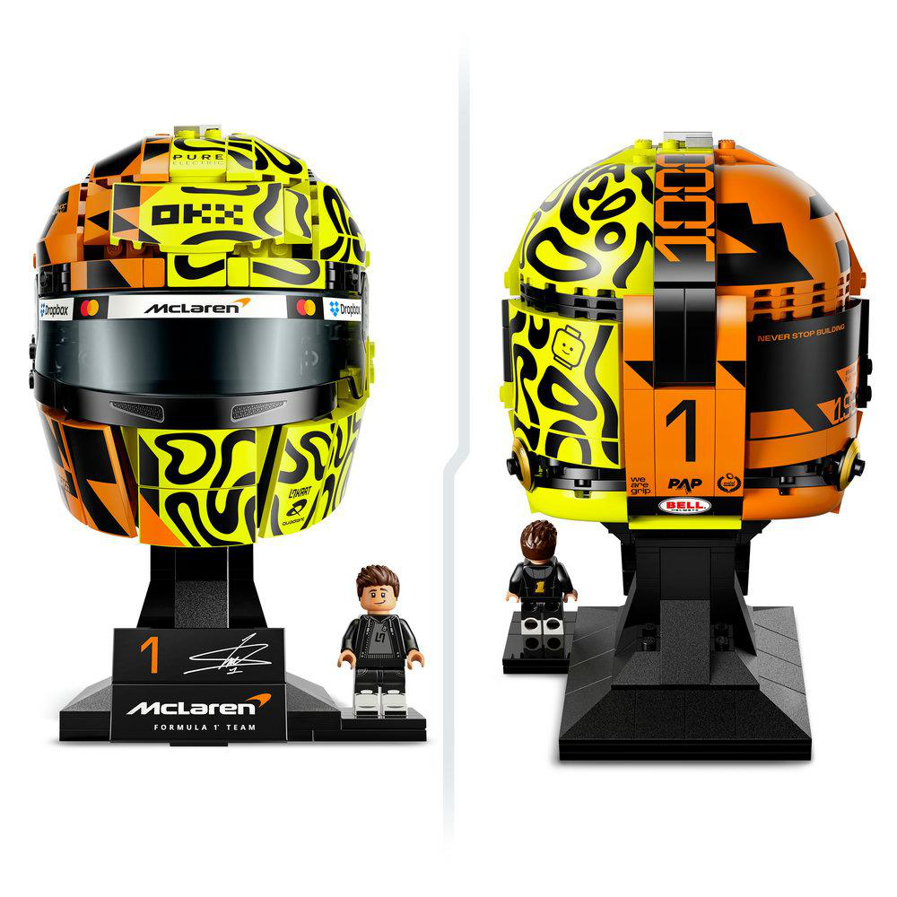 Zwei McLaren F1 Lego-Helme, einer mit Minifiguren-Displayständer. Gelb, orange, schwarz.
