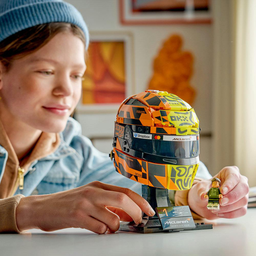 Eine Person baut einen Lego McLaren Helm mit einer Minifigur.