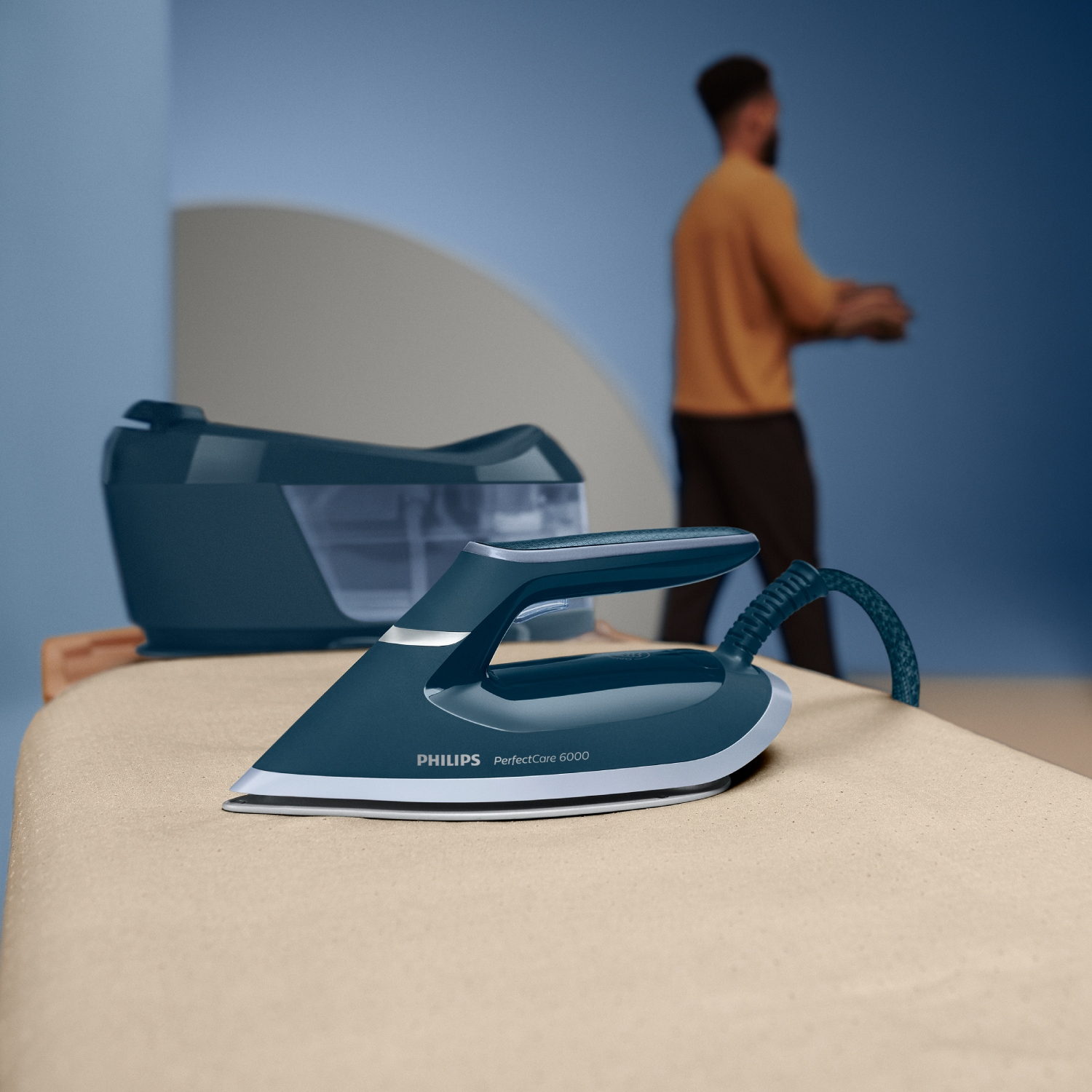 Un soporte azul para plancha de vapor con plancha y depósito de agua sobre una tabla de planchar.