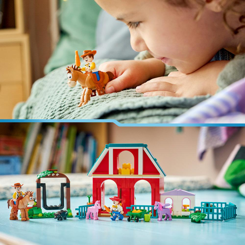 Ein Kind spielt mit LEGO-Figuren, die eine Farm mit Pferden und einem Stall darstellen.