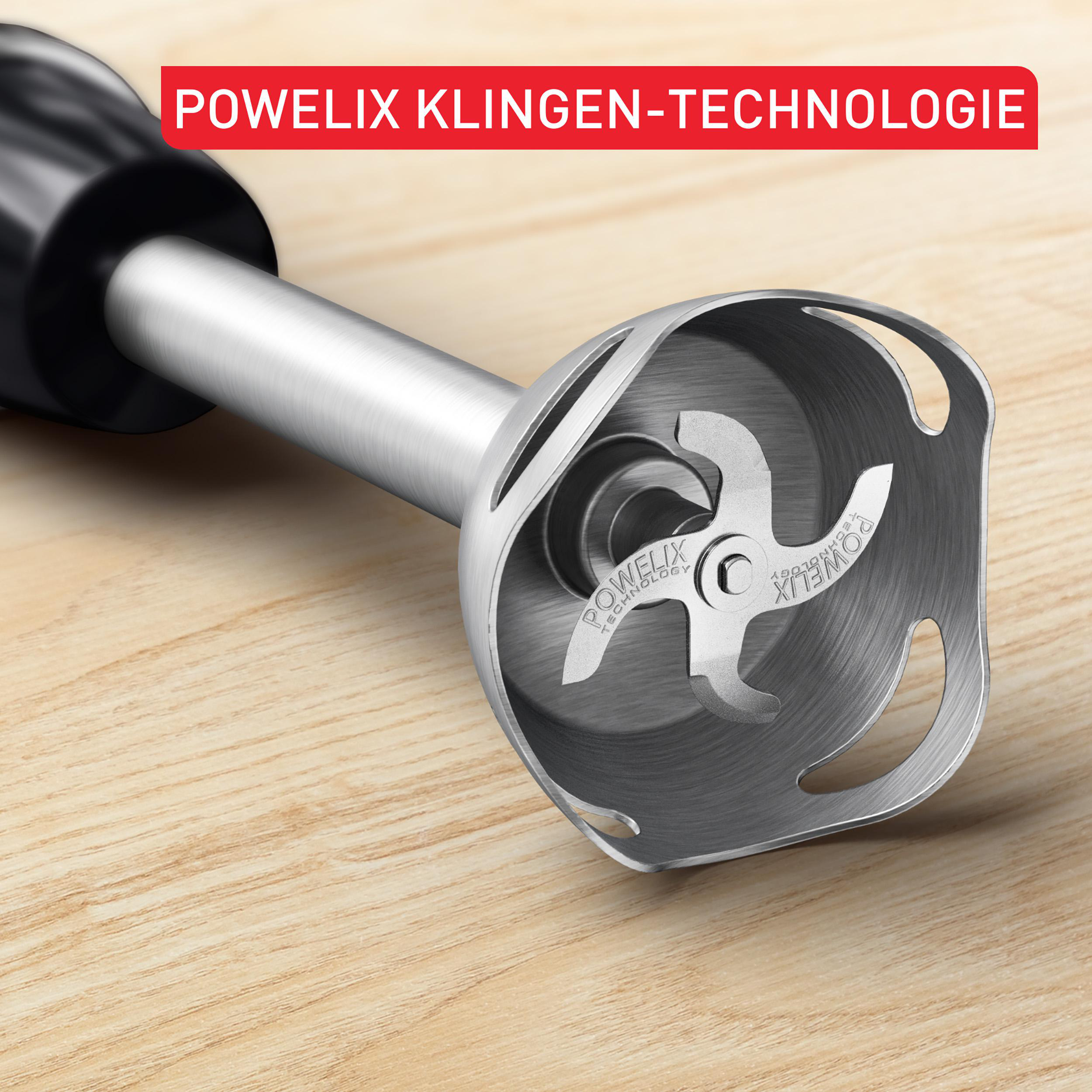 Ein Stabmixerfuß mit Metallklingen auf einem Holztisch. Roter Text oben.