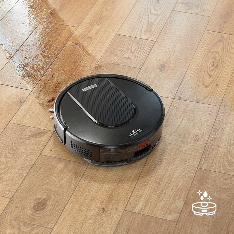 Egy fekete robotporszívó nedves fapadlót tisztít.