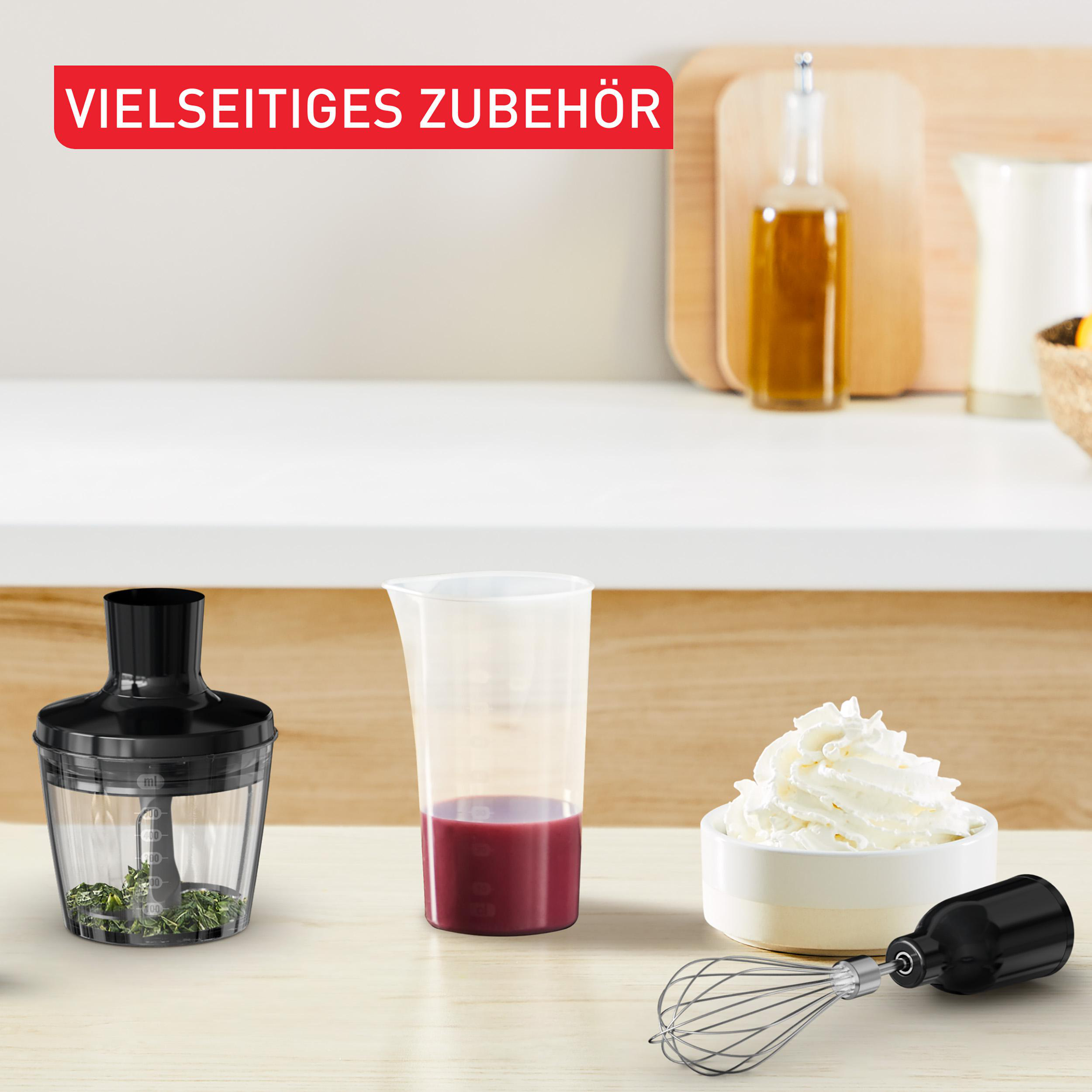 Küchenutensilien: Zerkleinerer mit Kräutern, Messbecher mit roter Flüssigkeit, Schlagsahne.