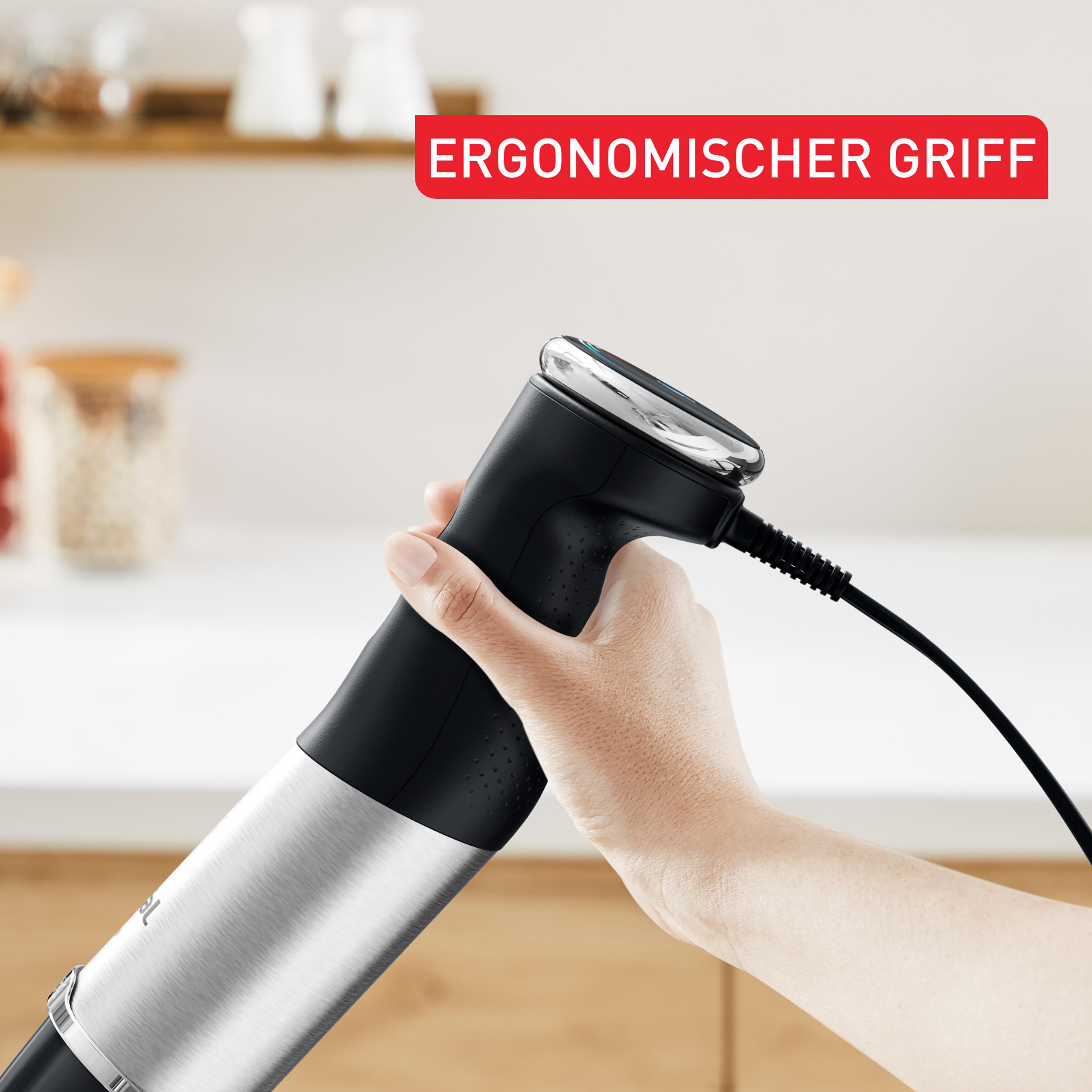 Hand hält schwarzen Stabmixer mit silbernem Detail. Roter Text: Ergonomischer Griff.