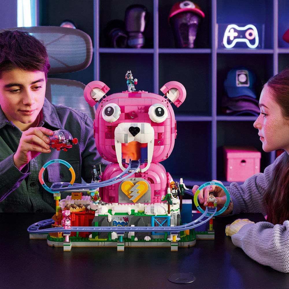 Kinder bauen einen rosa Bären-Achterbahn-Spielzeug-Set mit Figuren.