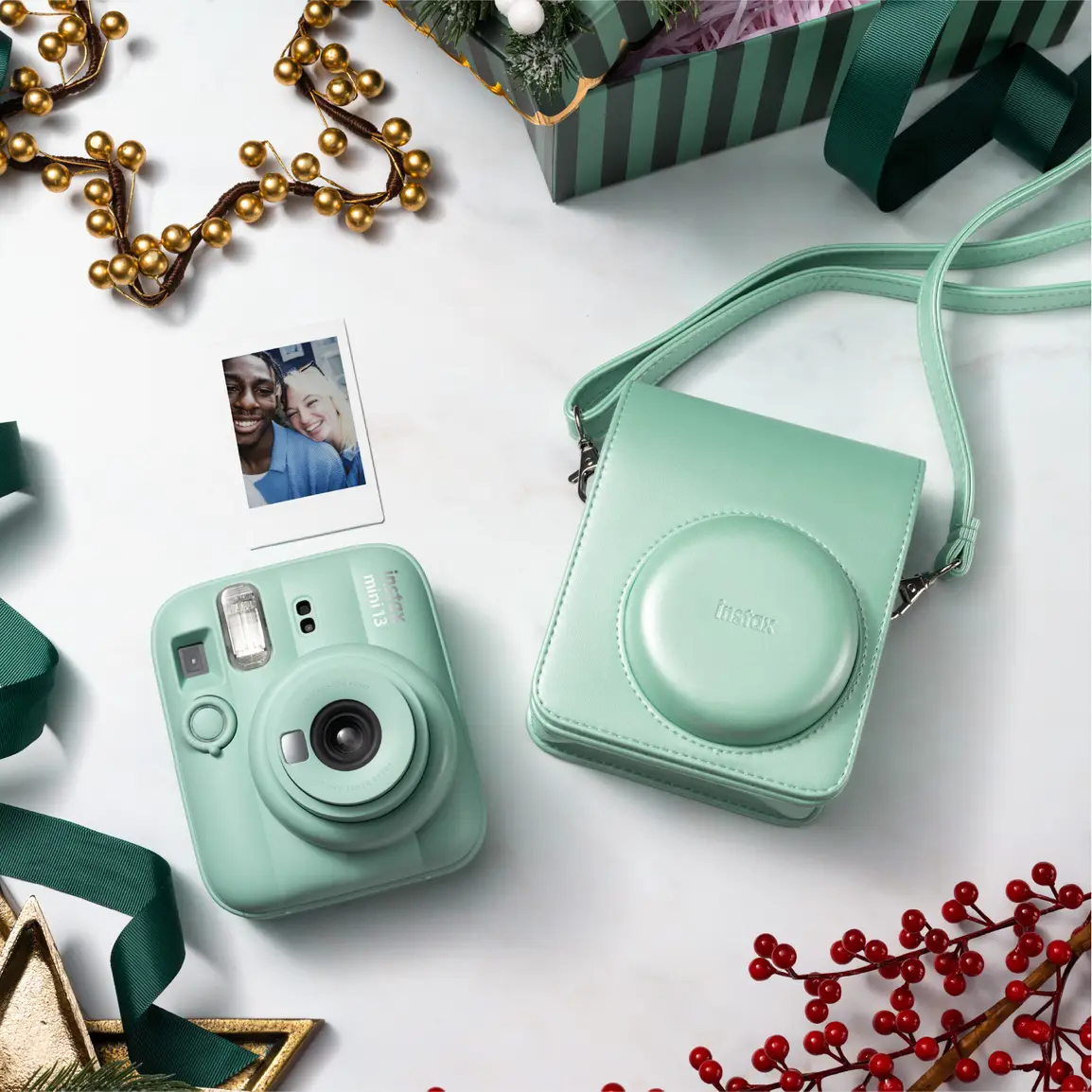 Appareil photo instantané vert menthe avec étui, photo et décorations.
