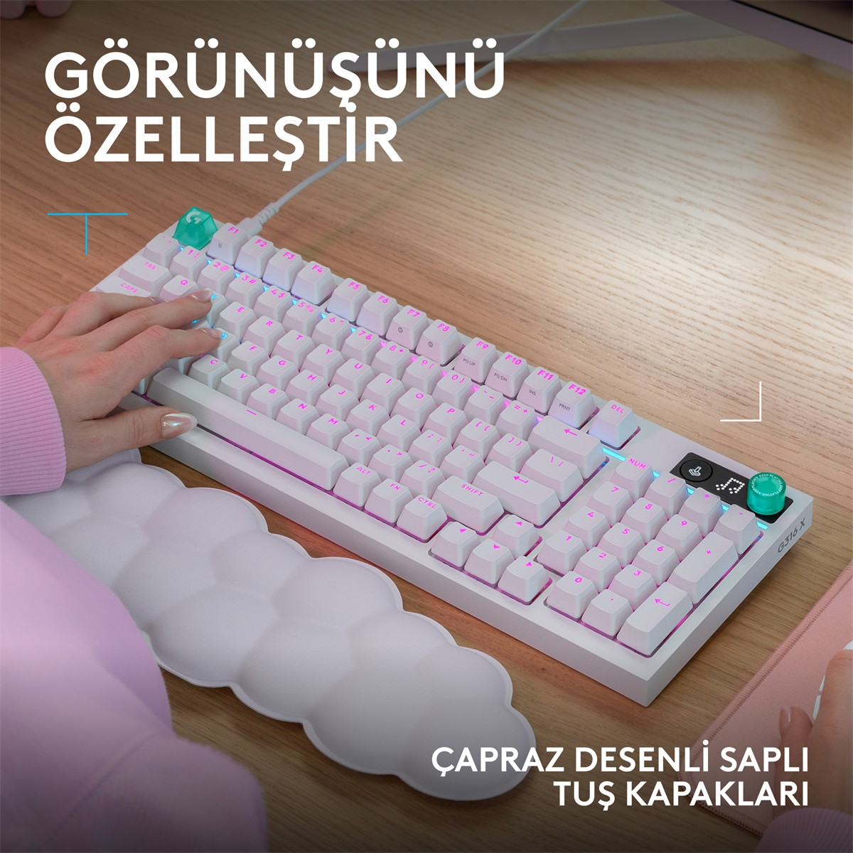 Pembe aydınlatmalı beyaz klavye ve onu kullanan bir el.