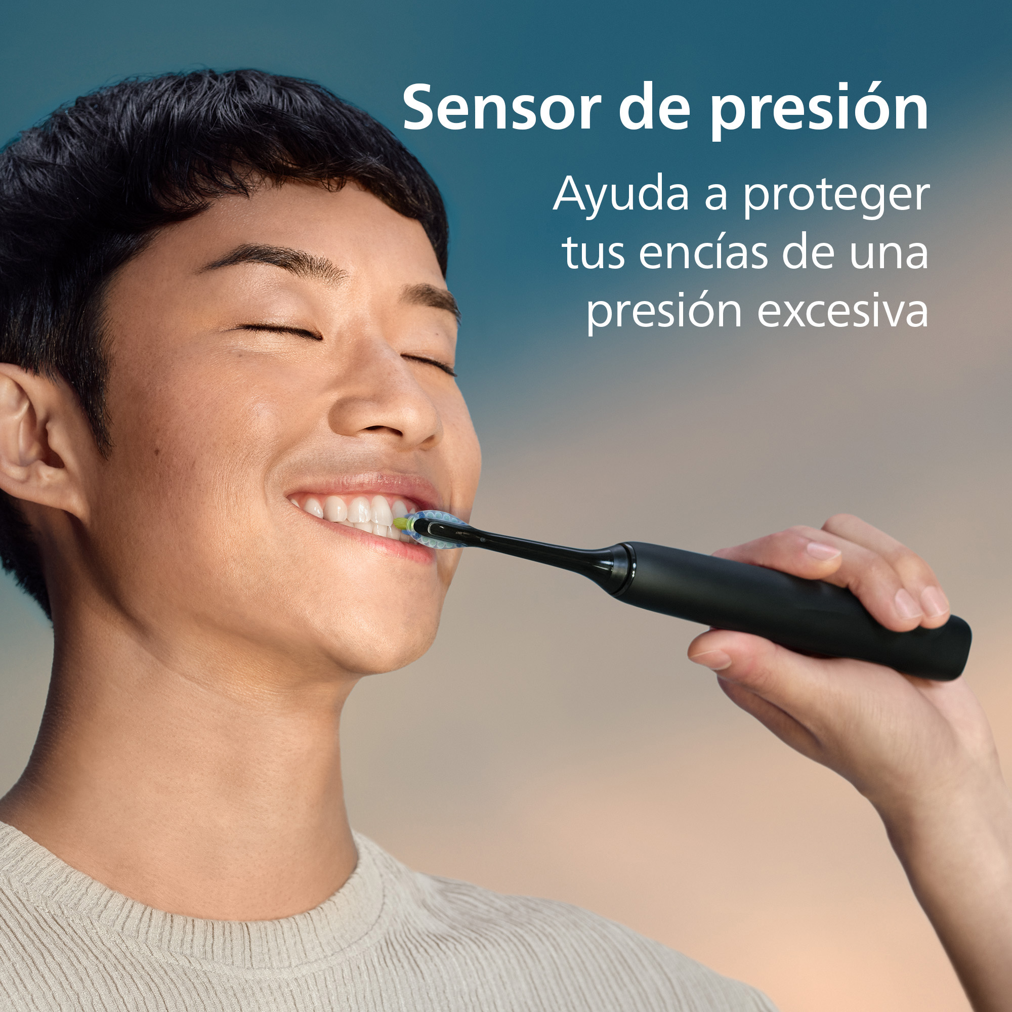 Hombre cepillándose los dientes con cepillo eléctrico. Se ve sensor de presión.